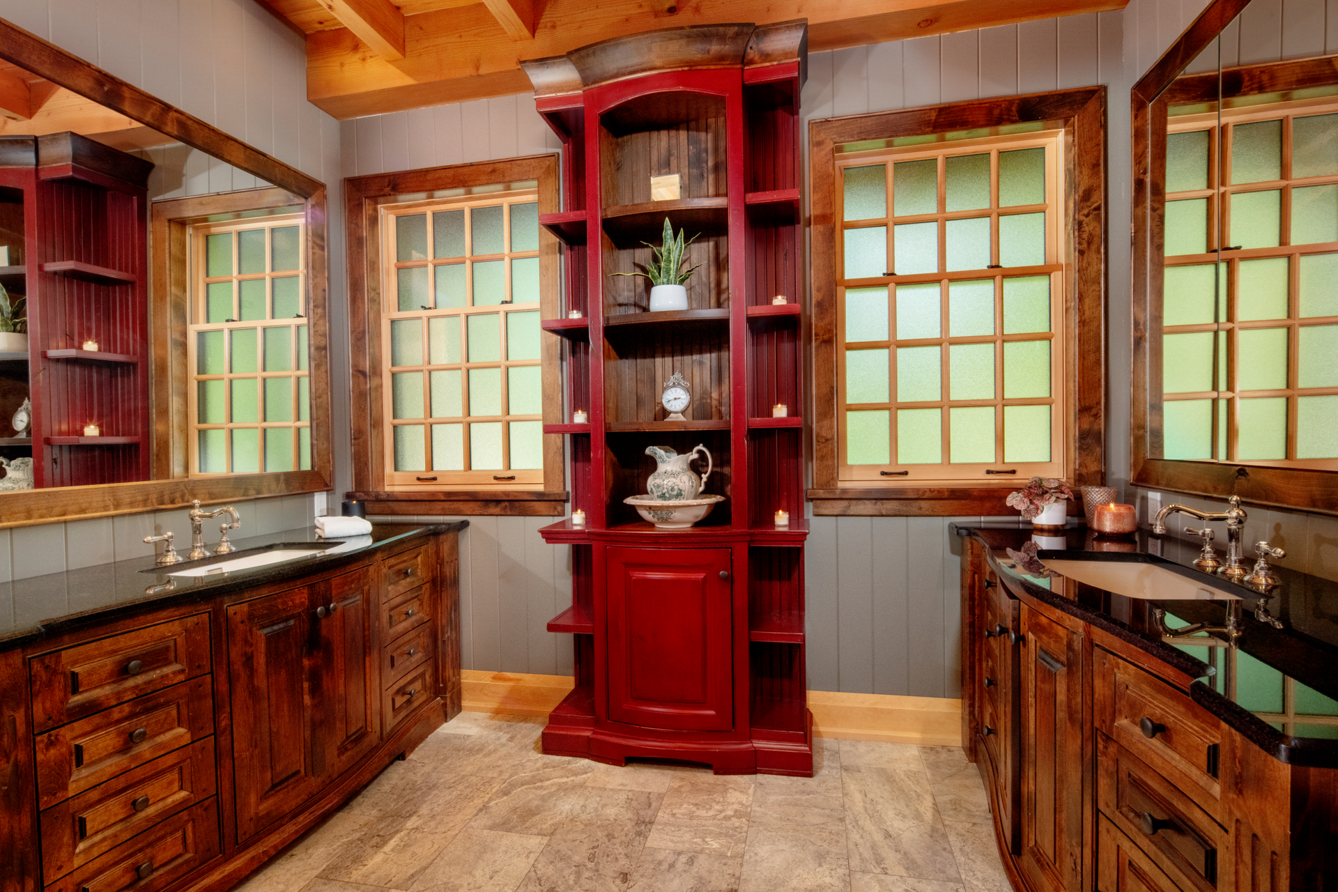 A bathroom with two sinks and a red cabinet