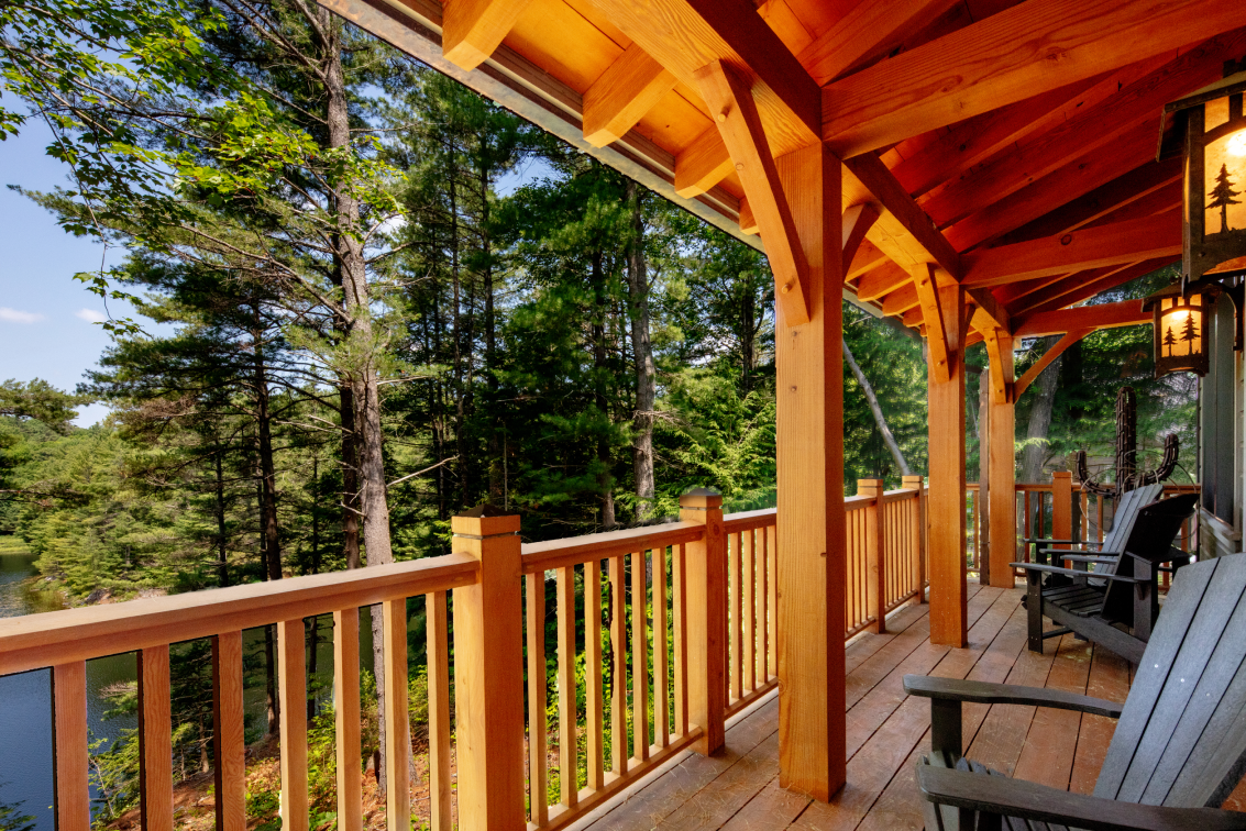 A wooden deck with a view of a lake and trees