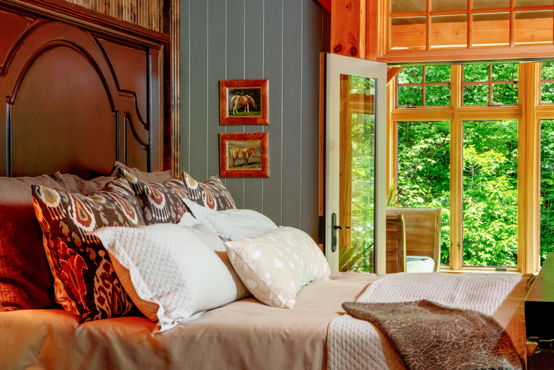 A bedroom with a large bed and a large window.