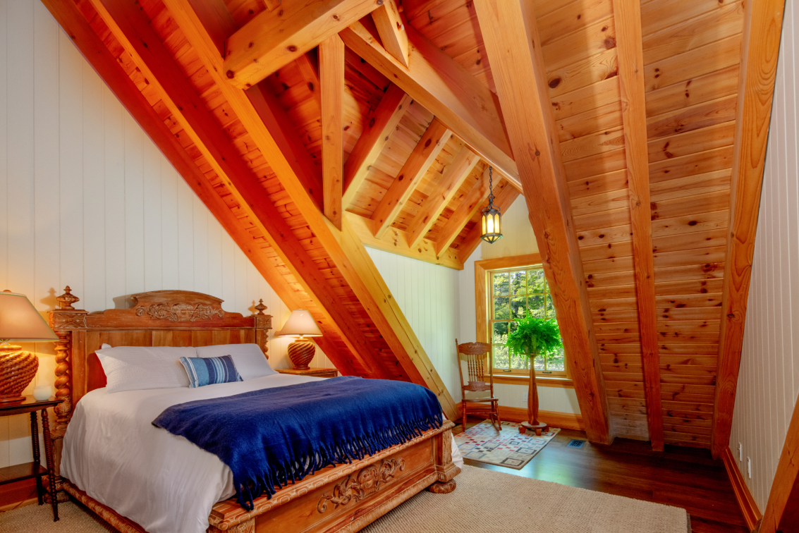 A bedroom with a king size bed and a wooden ceiling.