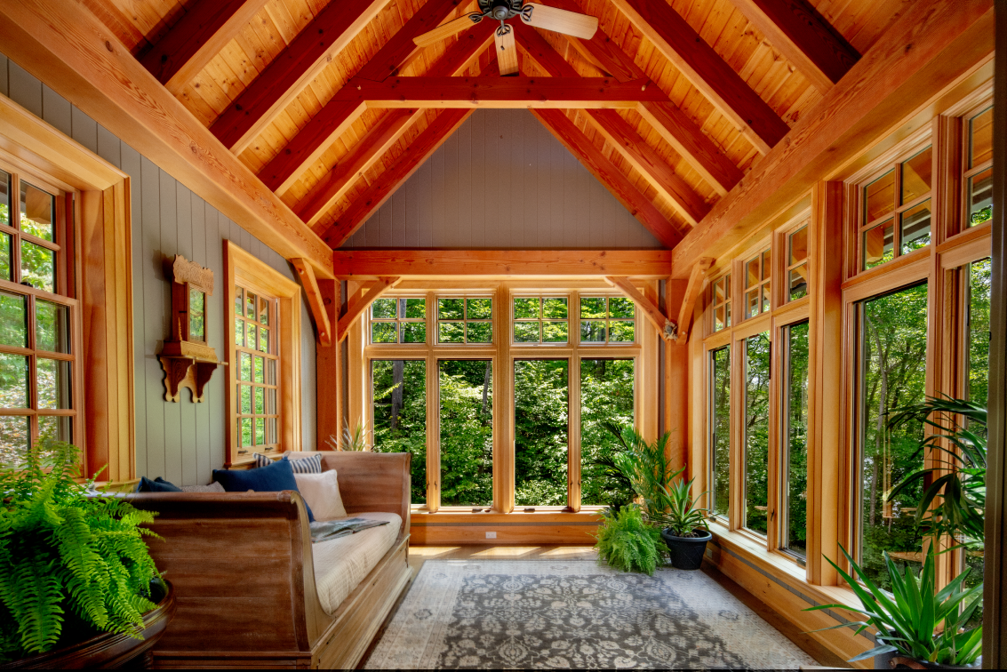 A living room with a lot of windows and a ceiling fan.