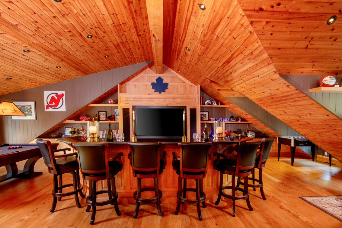 A game room with a table , chairs , a television and a pool table.