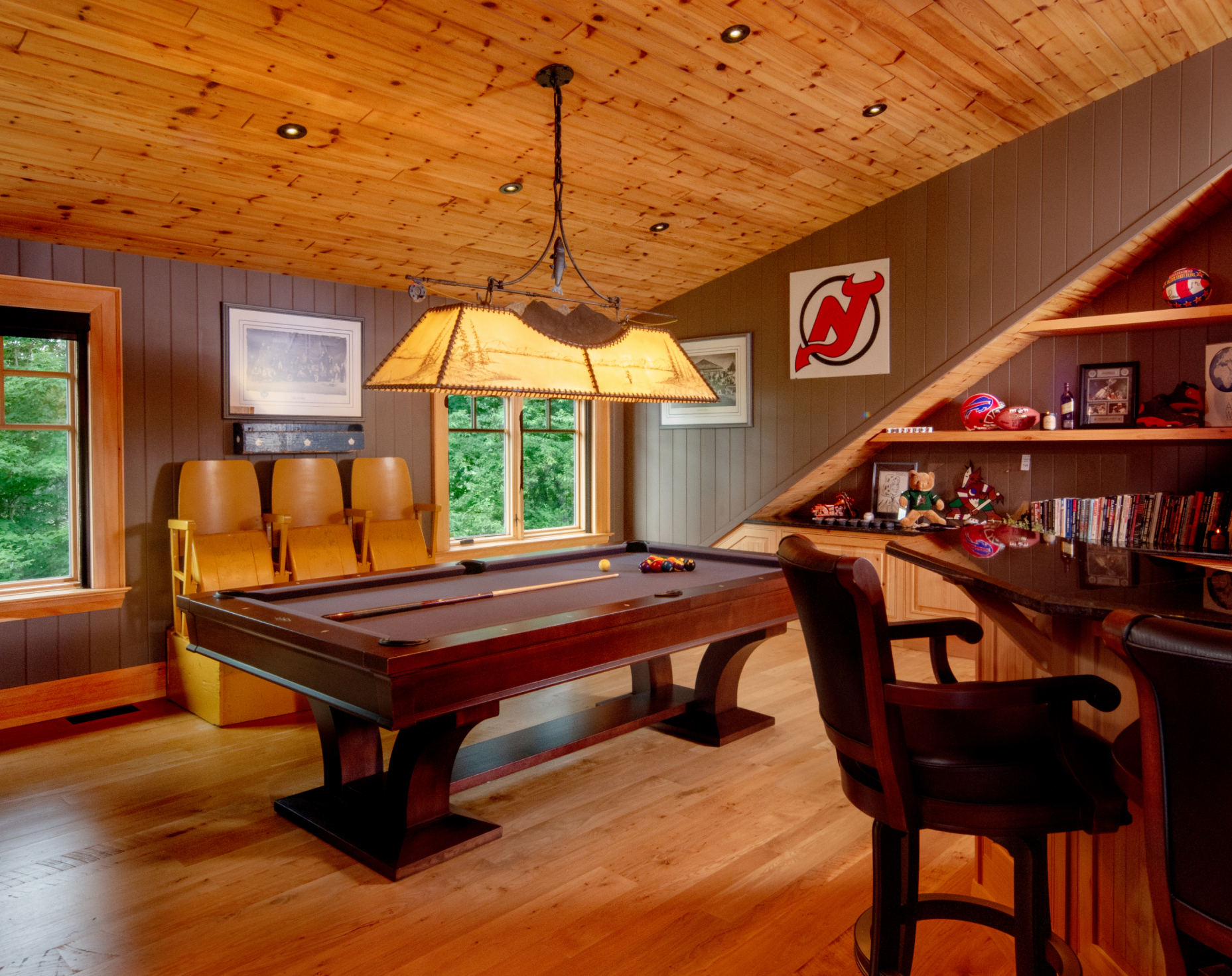 A pool table in a room with a new jersey devils logo on the wall