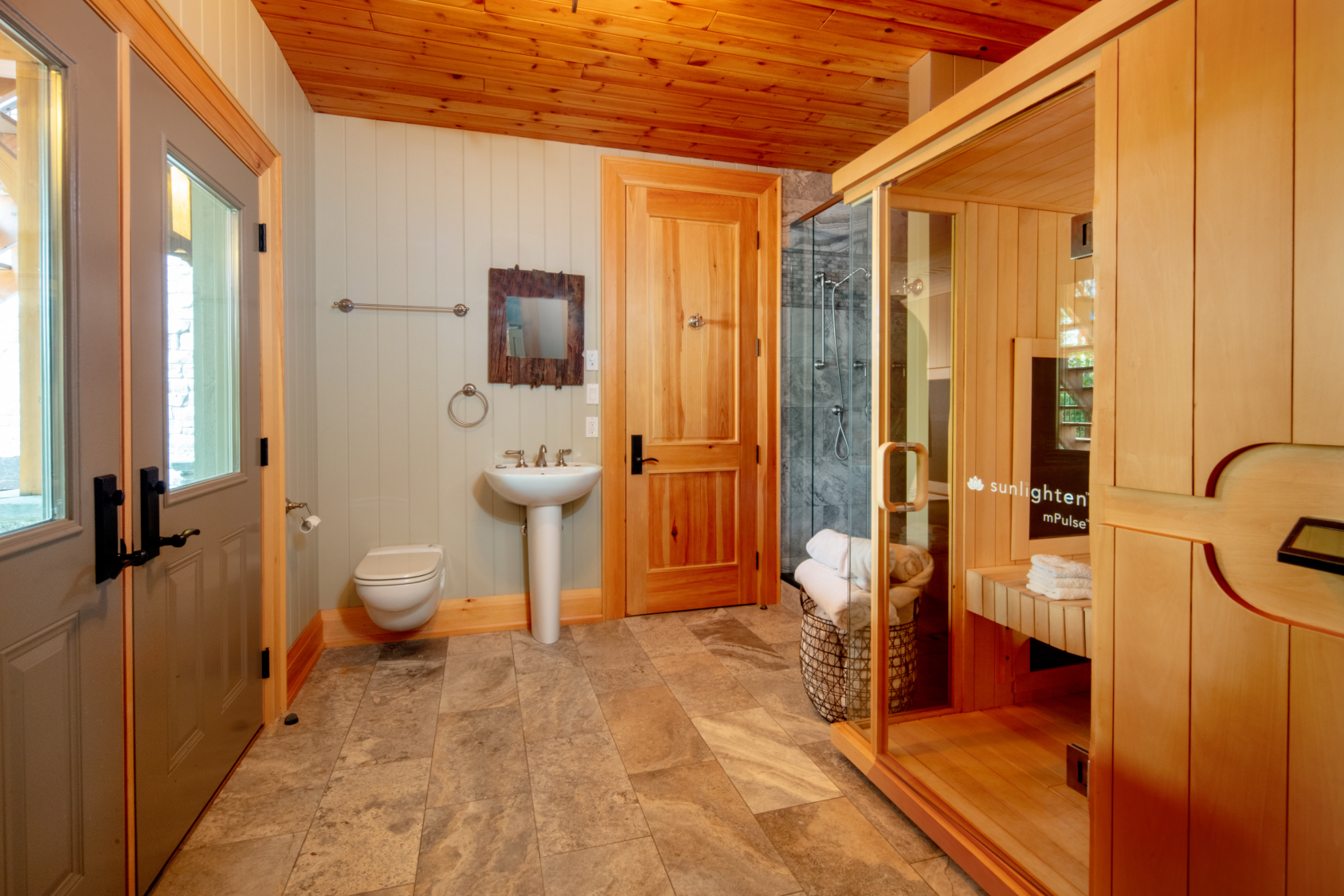 A bathroom with a sink , toilet , and sauna.