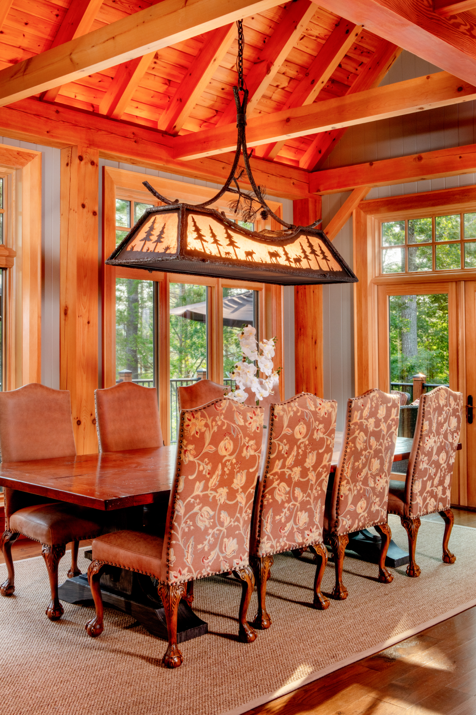 A dining room with a table and chairs and a chandelier hanging from the ceiling.
