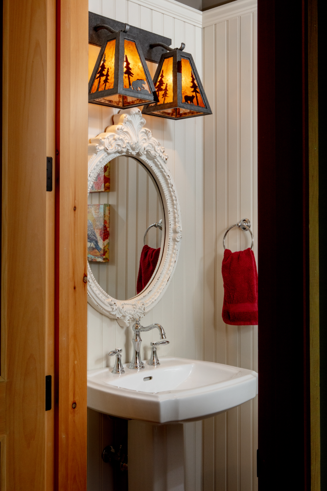 A bathroom with a sink , mirror and light fixture.