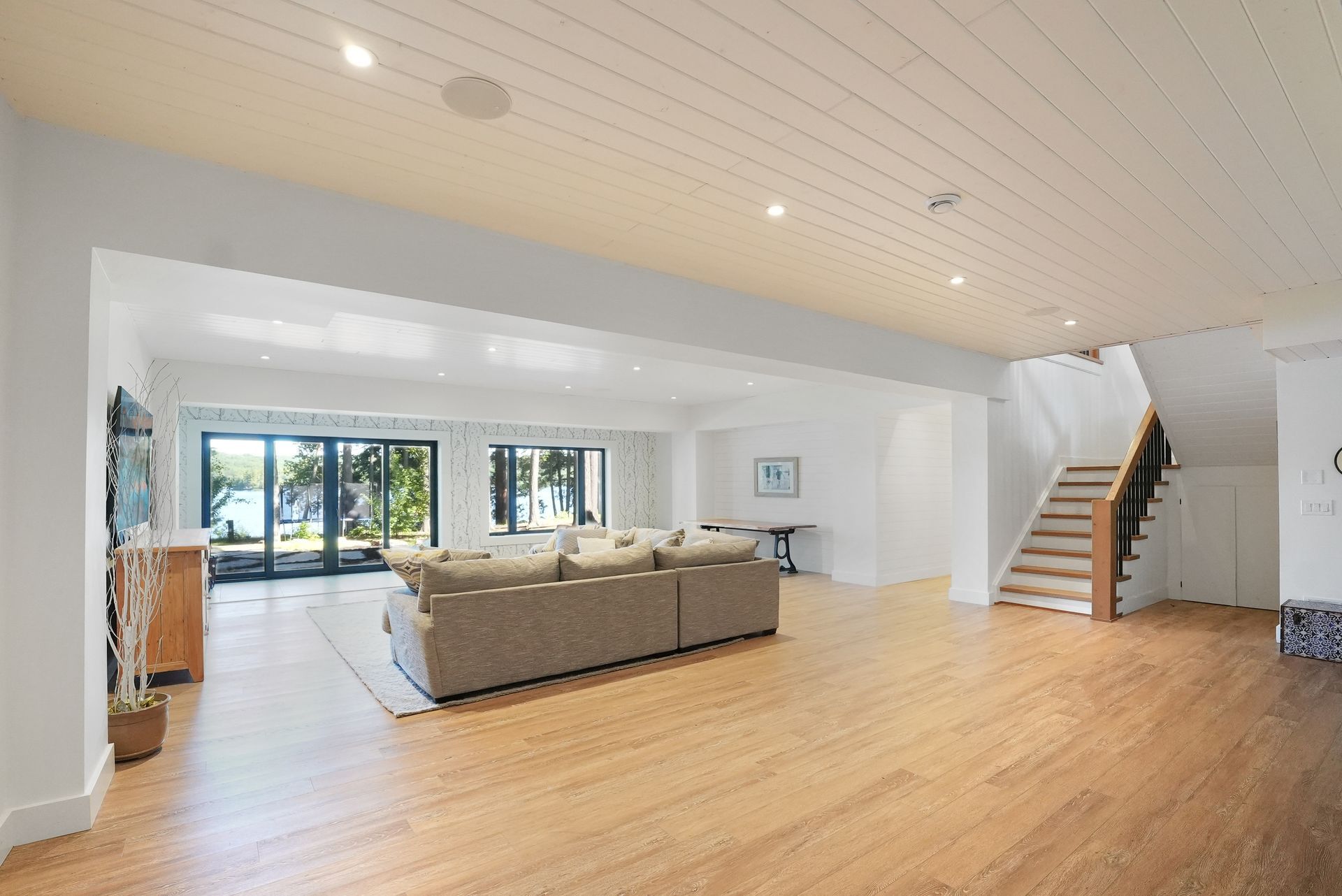 A home gym with wooden floors and a lot of exercise equipment.