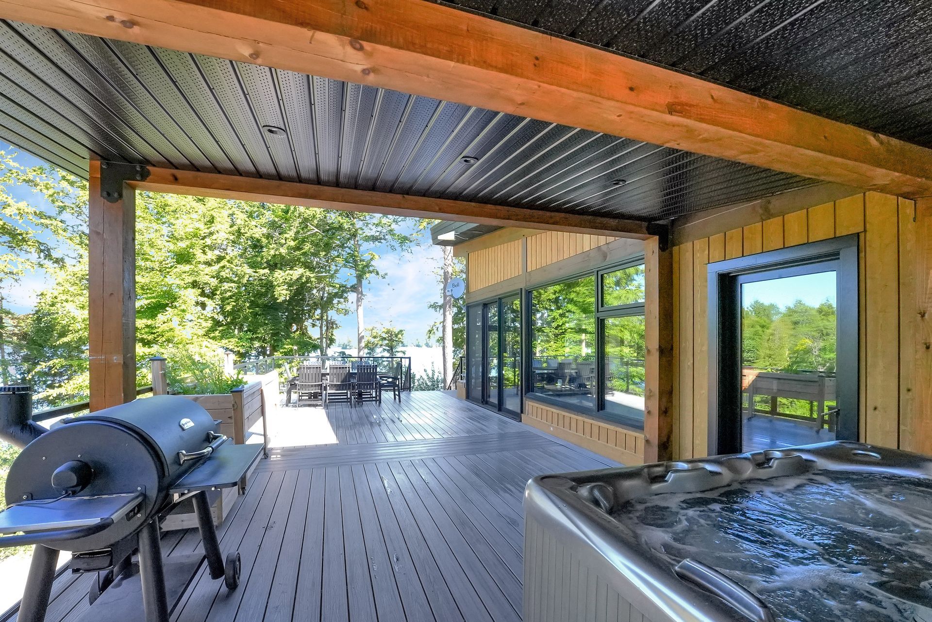 Two red adirondack chairs are sitting on a dock overlooking a lake.
