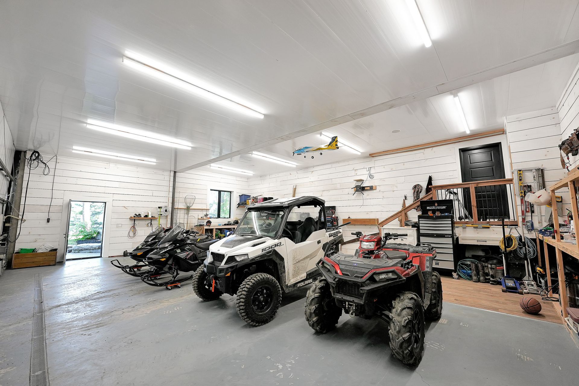 Two pink chairs are sitting on a dock overlooking a lake.