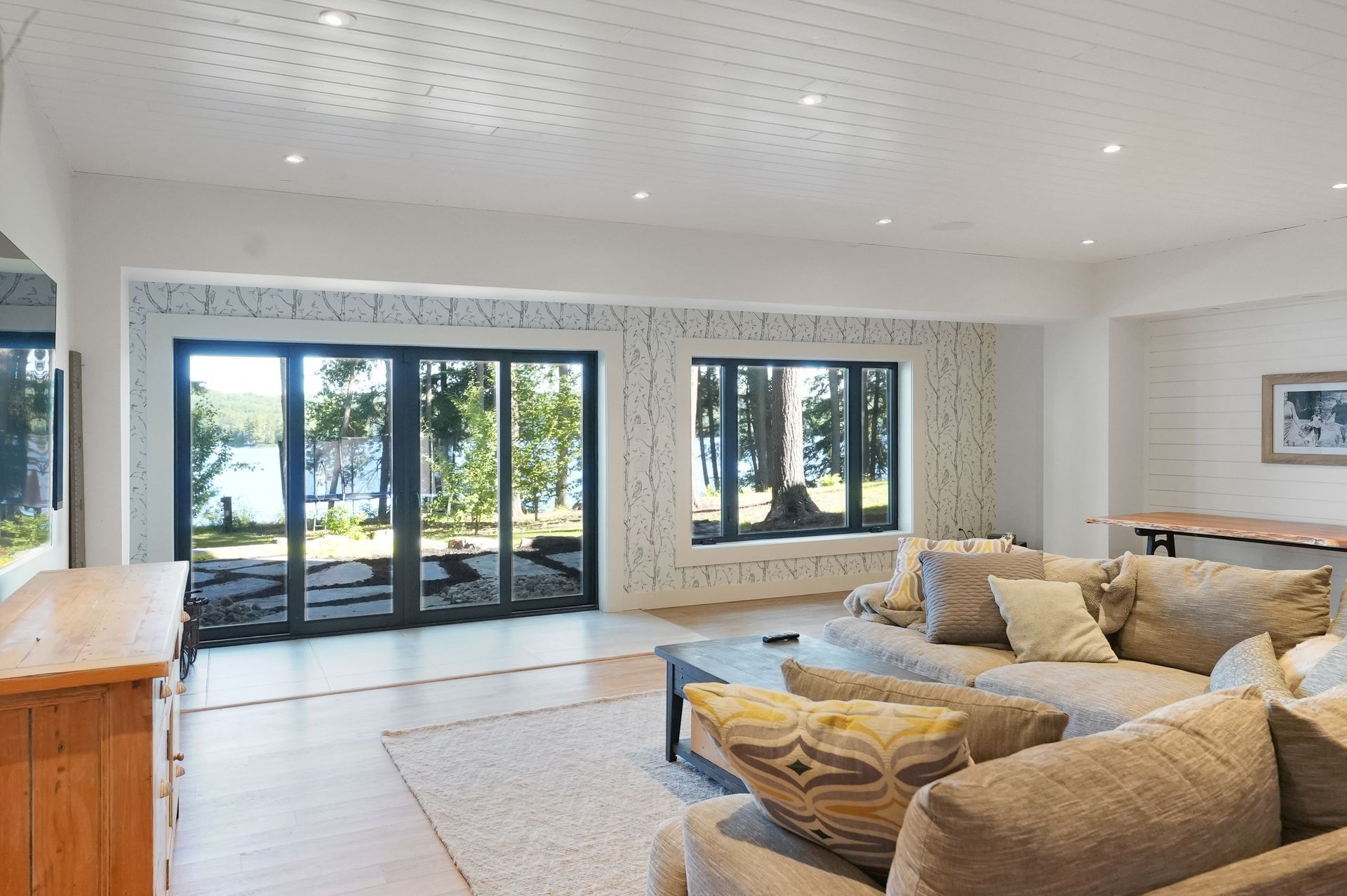 A living room with a couch , chair , television and fireplace.