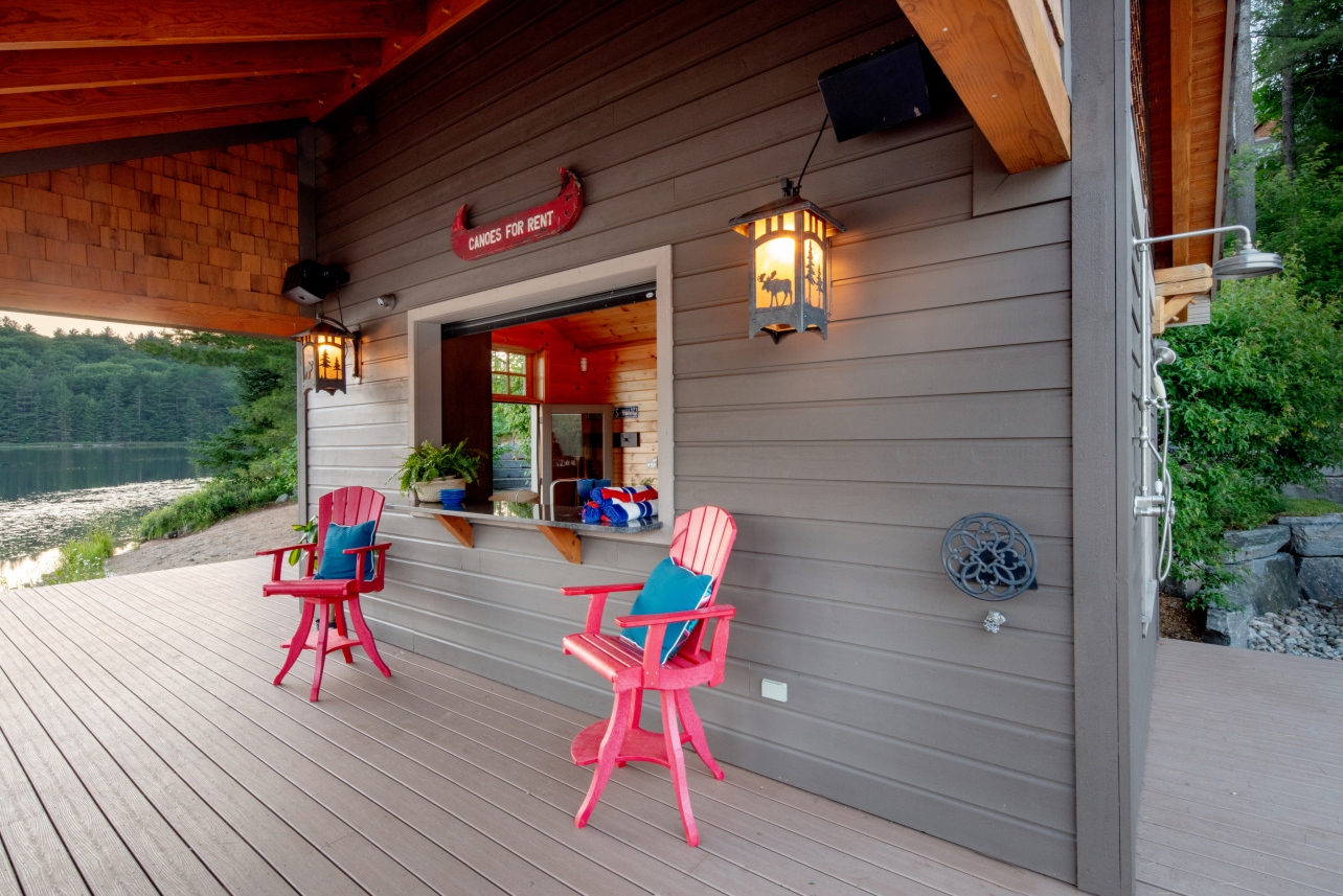 Two chairs are sitting on a deck in front of a building.