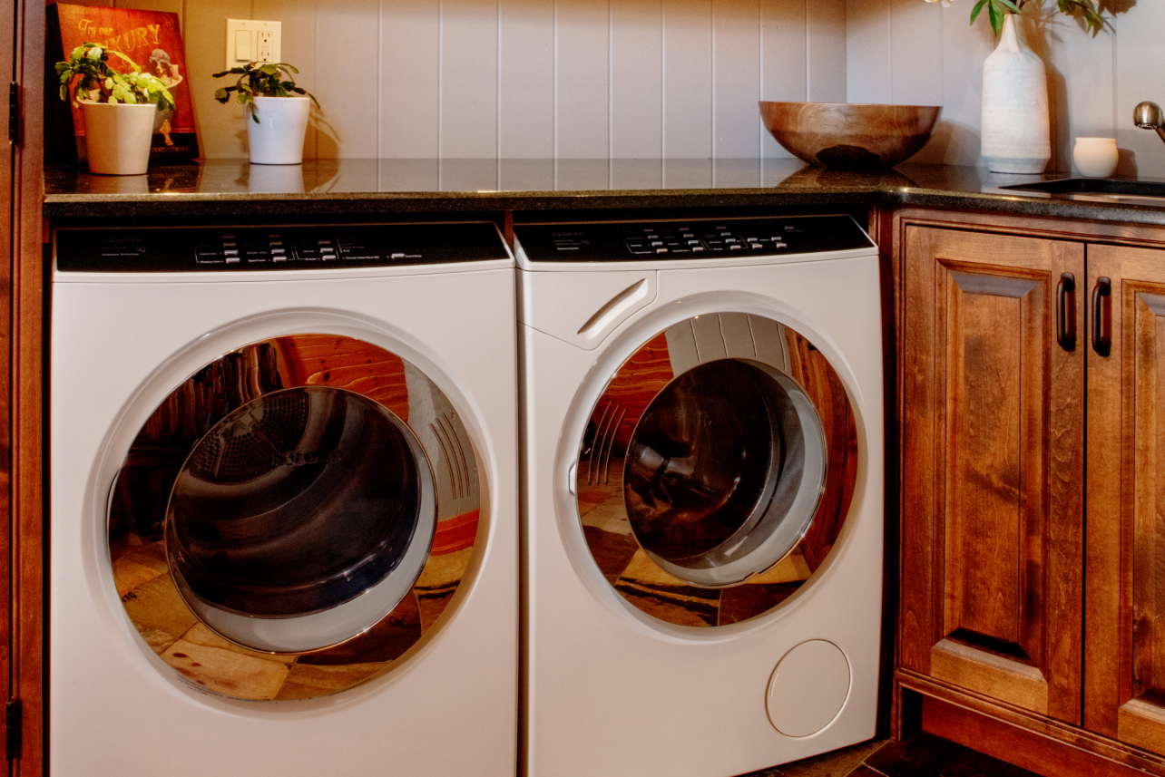 A washer and dryer are sitting on a counter in a laundry room.