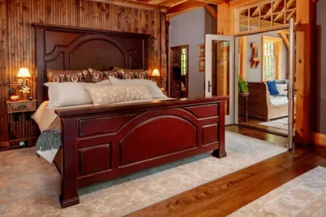 A bedroom with a king size bed and wooden walls