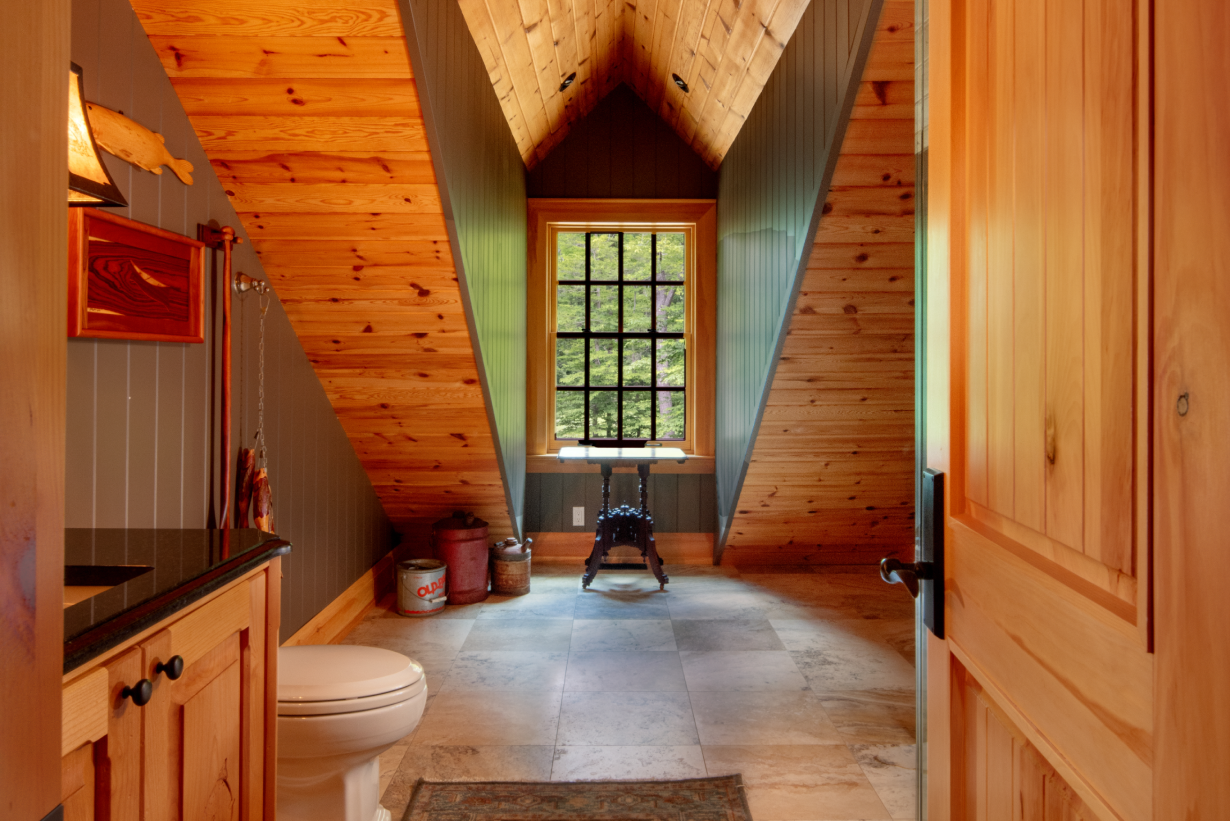 A bathroom with a toilet , sink , and window.