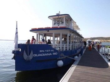 Um barco chamado guardião rio está atracado em um cais