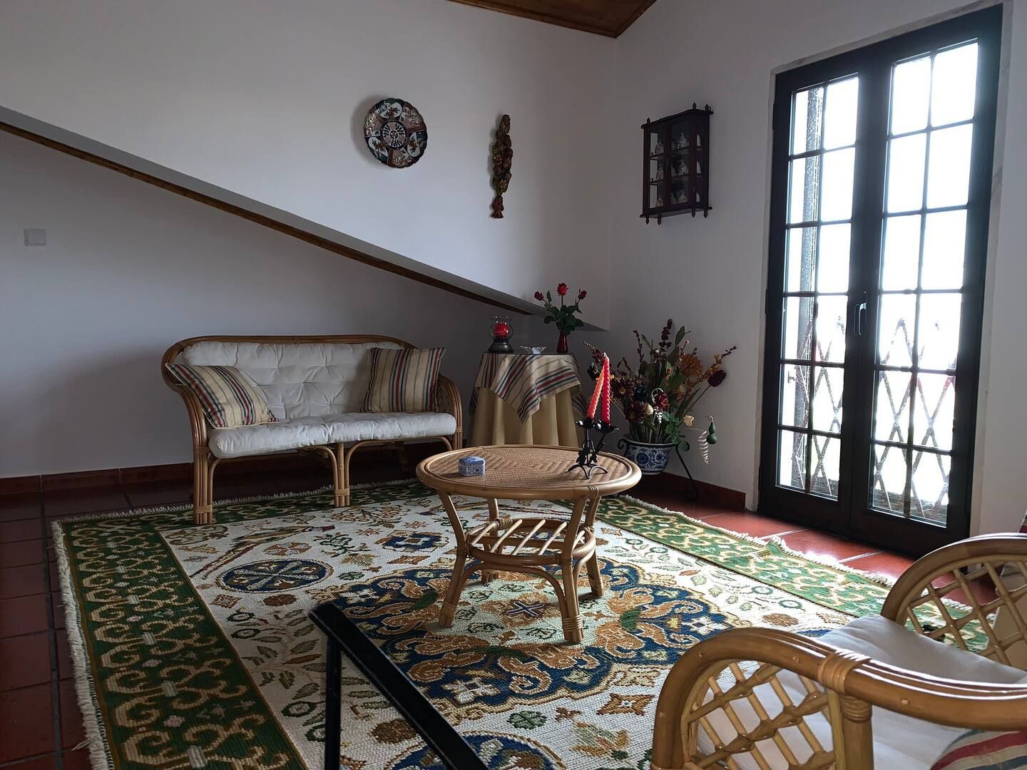 Uma sala de estar com sofá e cadeiras e um tapete