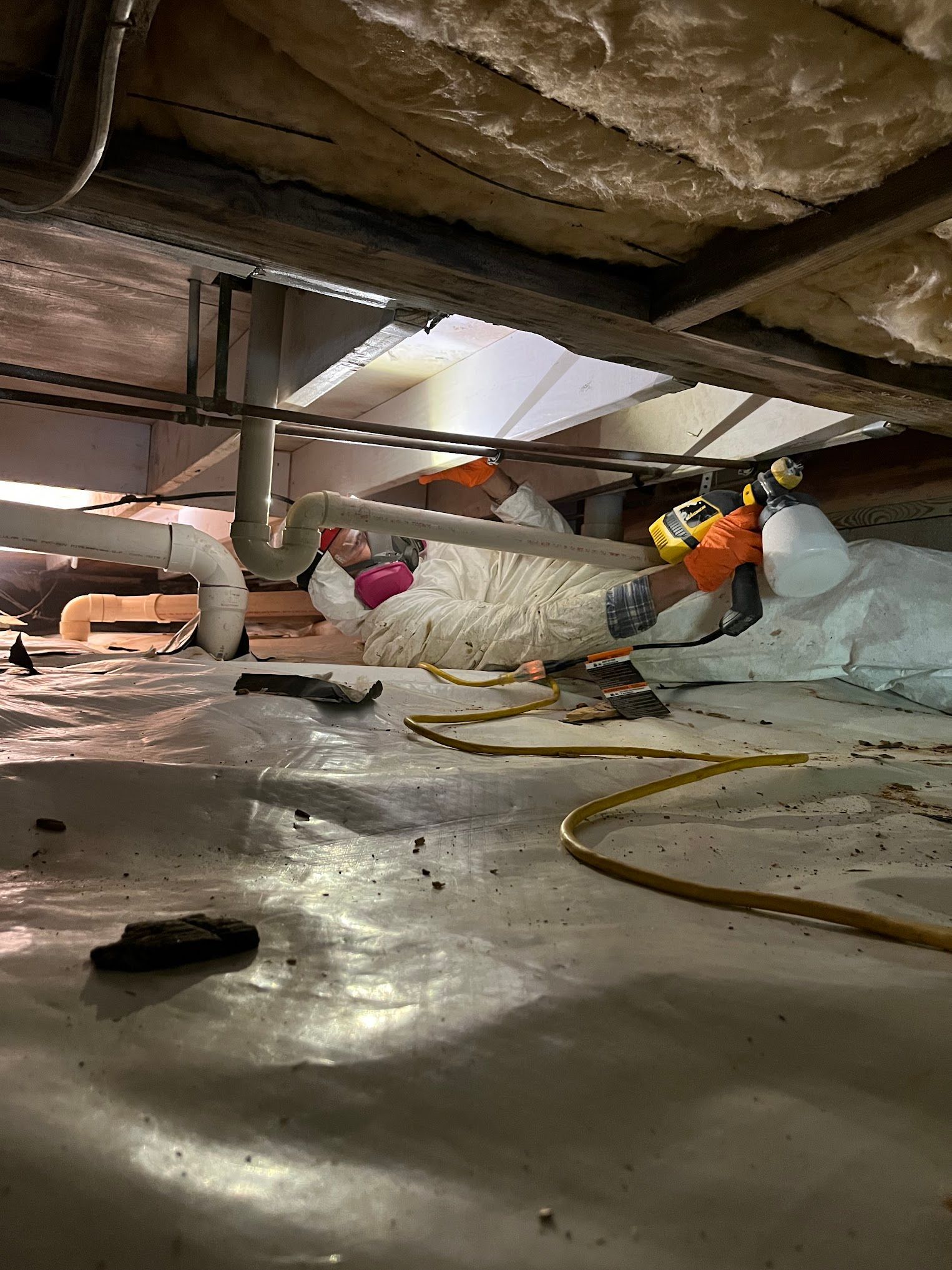A person is working on a pipe in a basement.