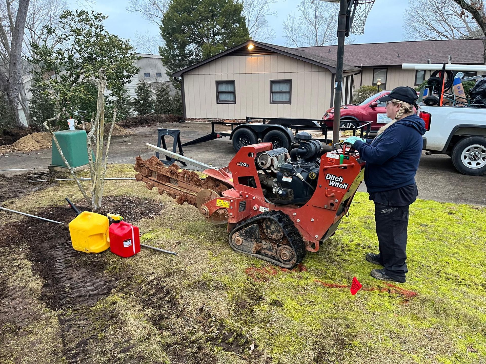 A man is standing next to a machine in a yard.