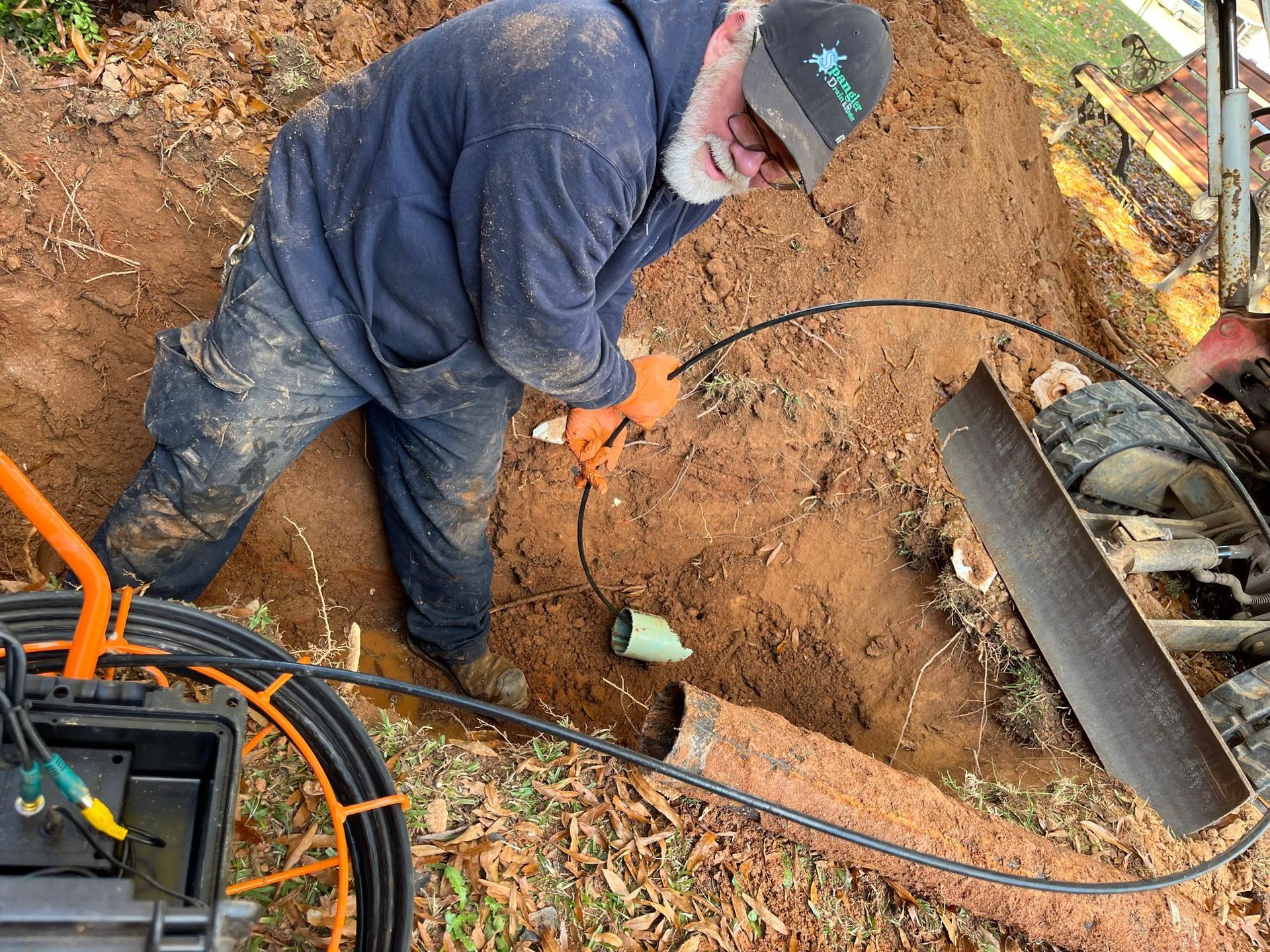 A man is digging a hole in the dirt with a camera.