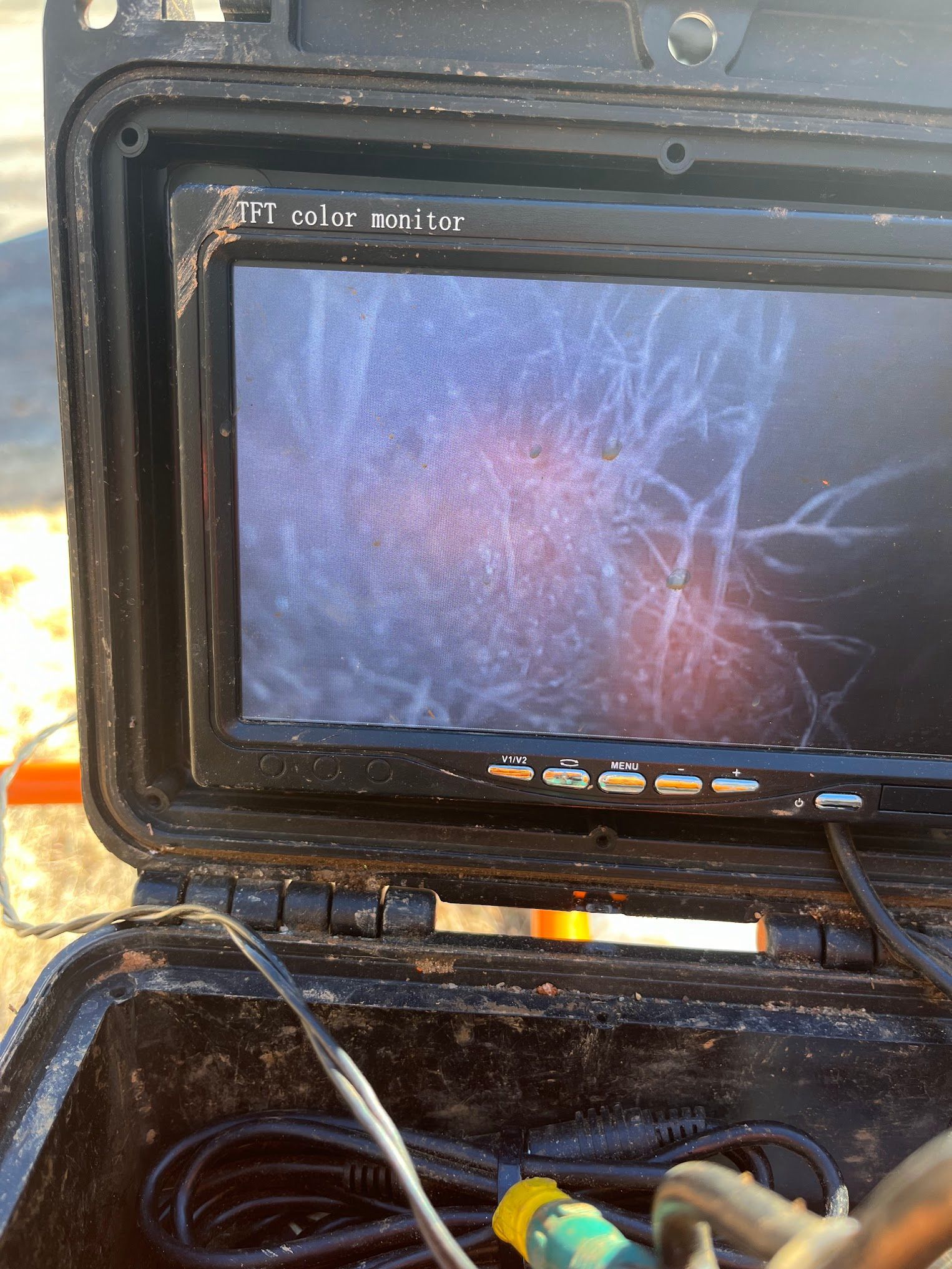 A camera is sitting in a case with a hose attached to it.