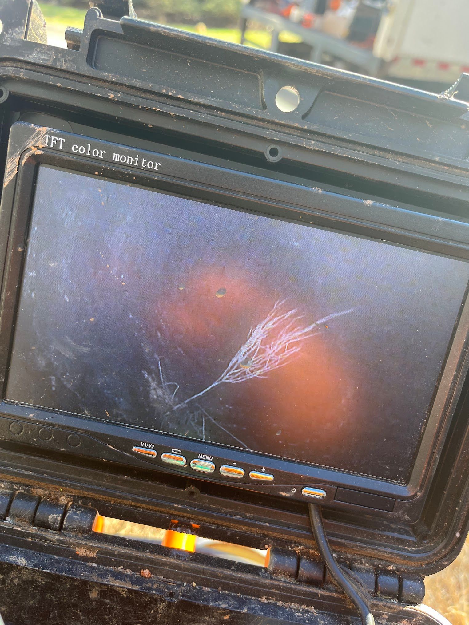 A camera with a broken screen is sitting in a case.