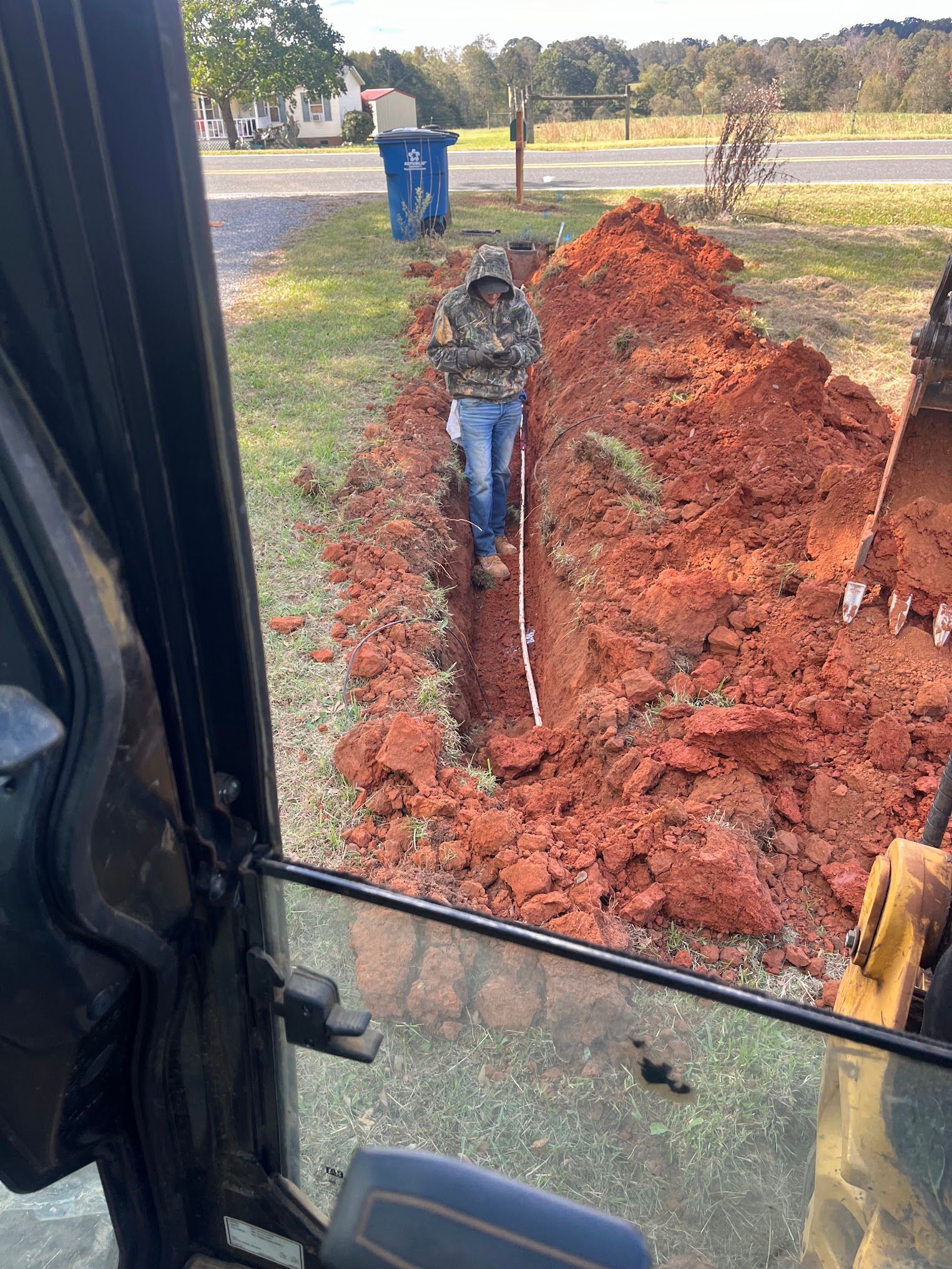 A man is digging a hole in the ground with a shovel.