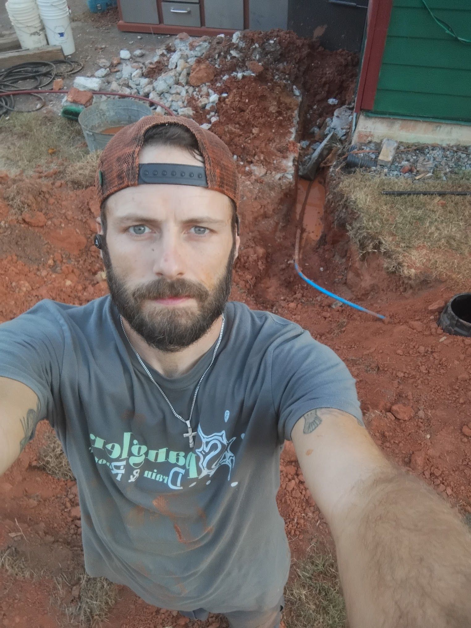 A man with a beard is taking a selfie in the dirt.