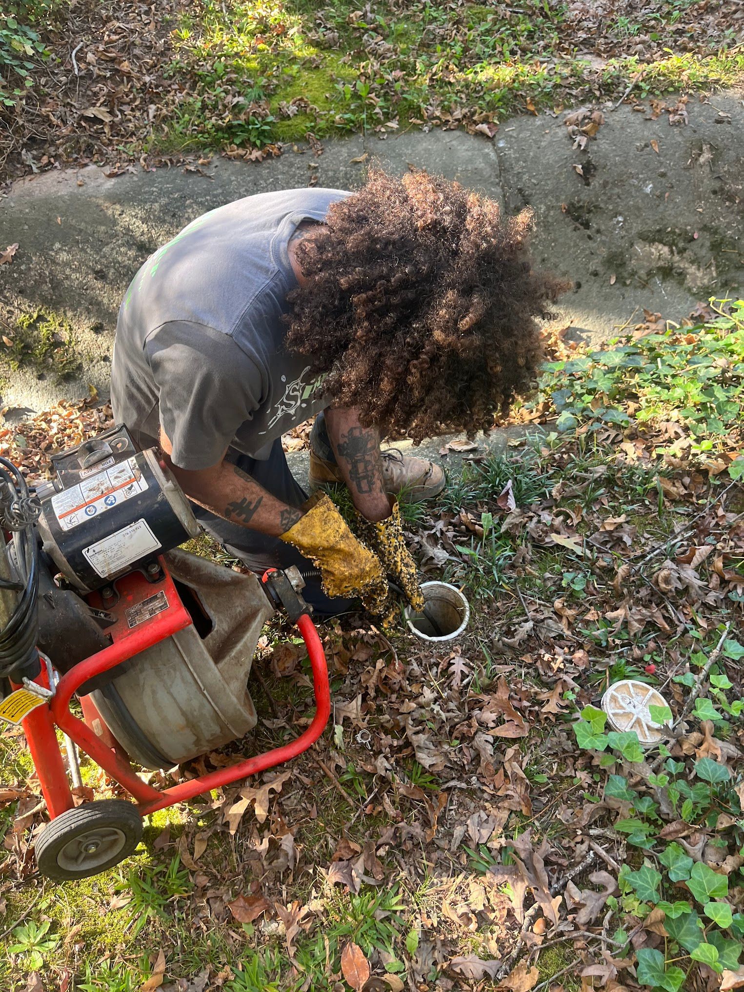 A man is using a drain cleaner to clean a drain.