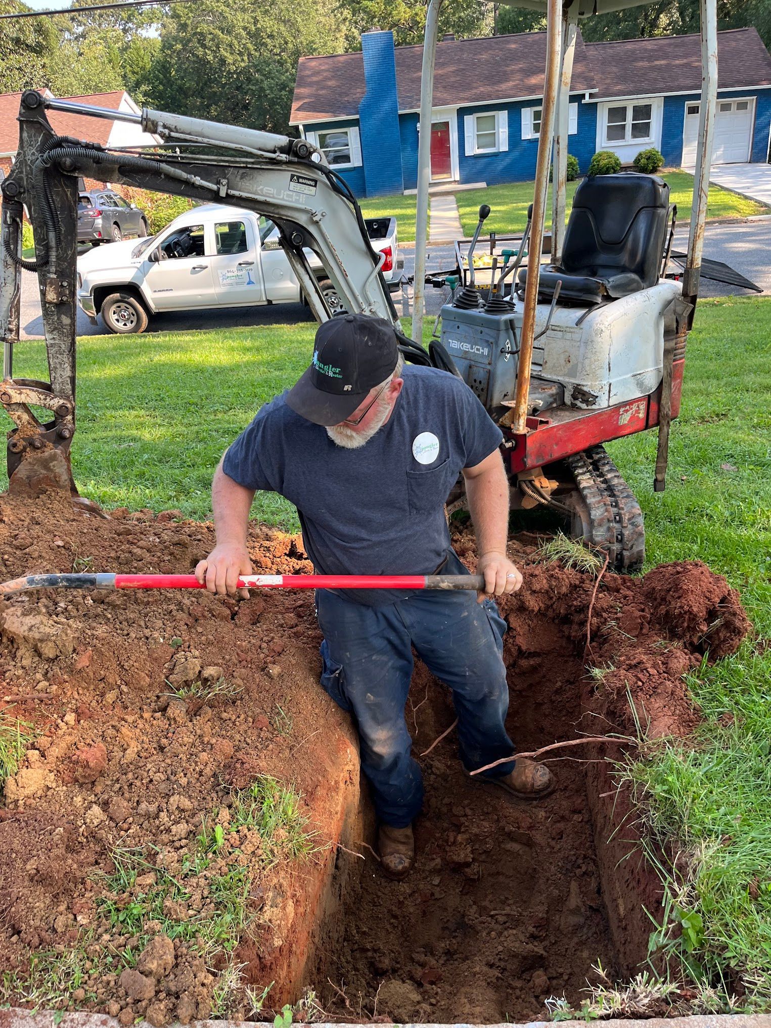 A man is digging a hole in the ground with a shovel.