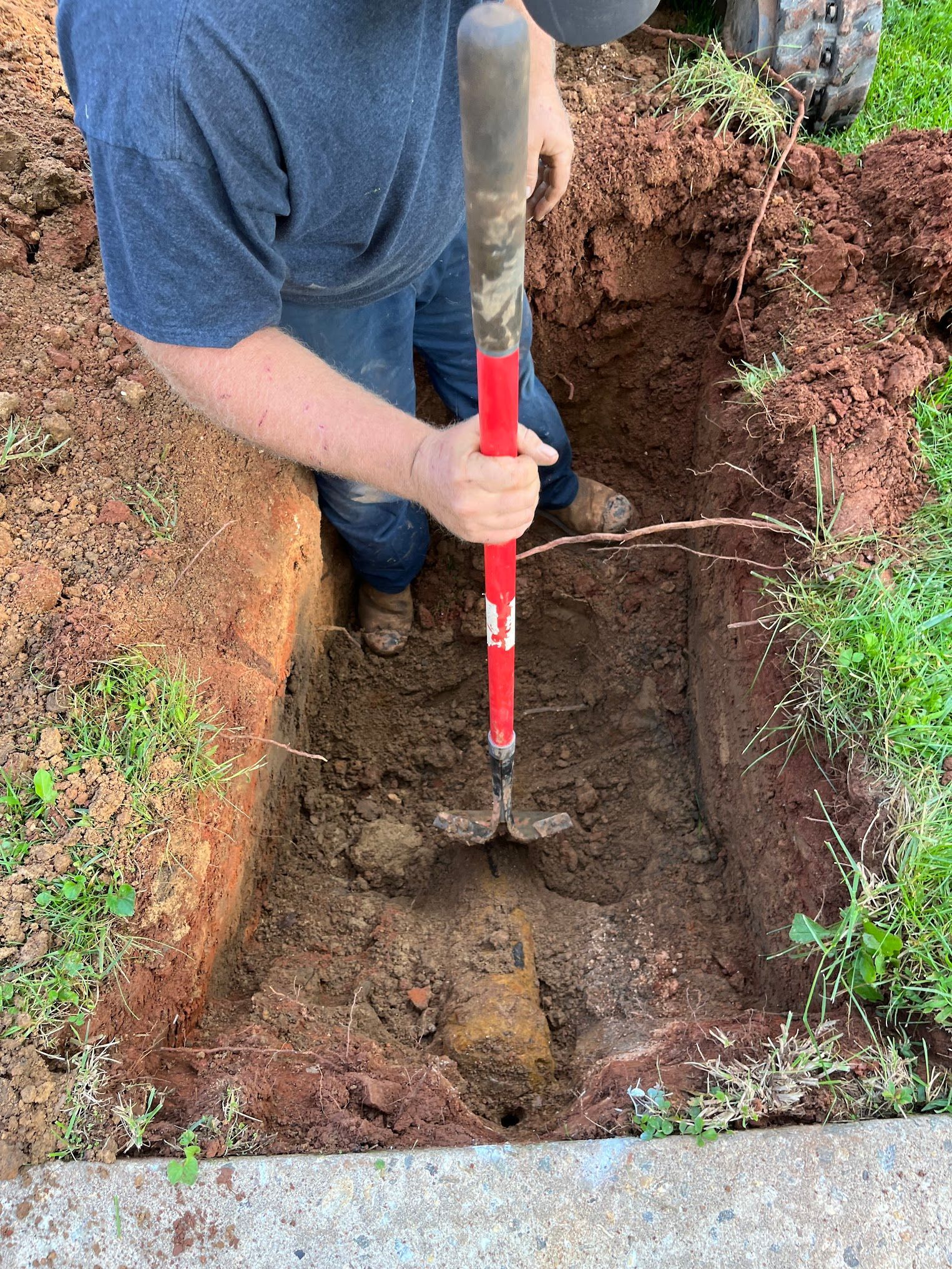 A man is digging a hole in the ground with a shovel.