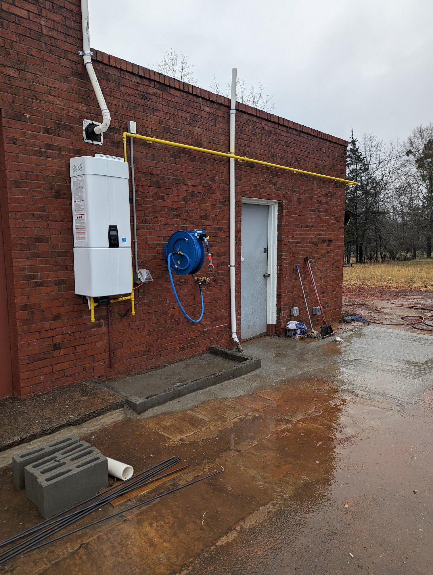 A brick building with a water heater on the side of it.