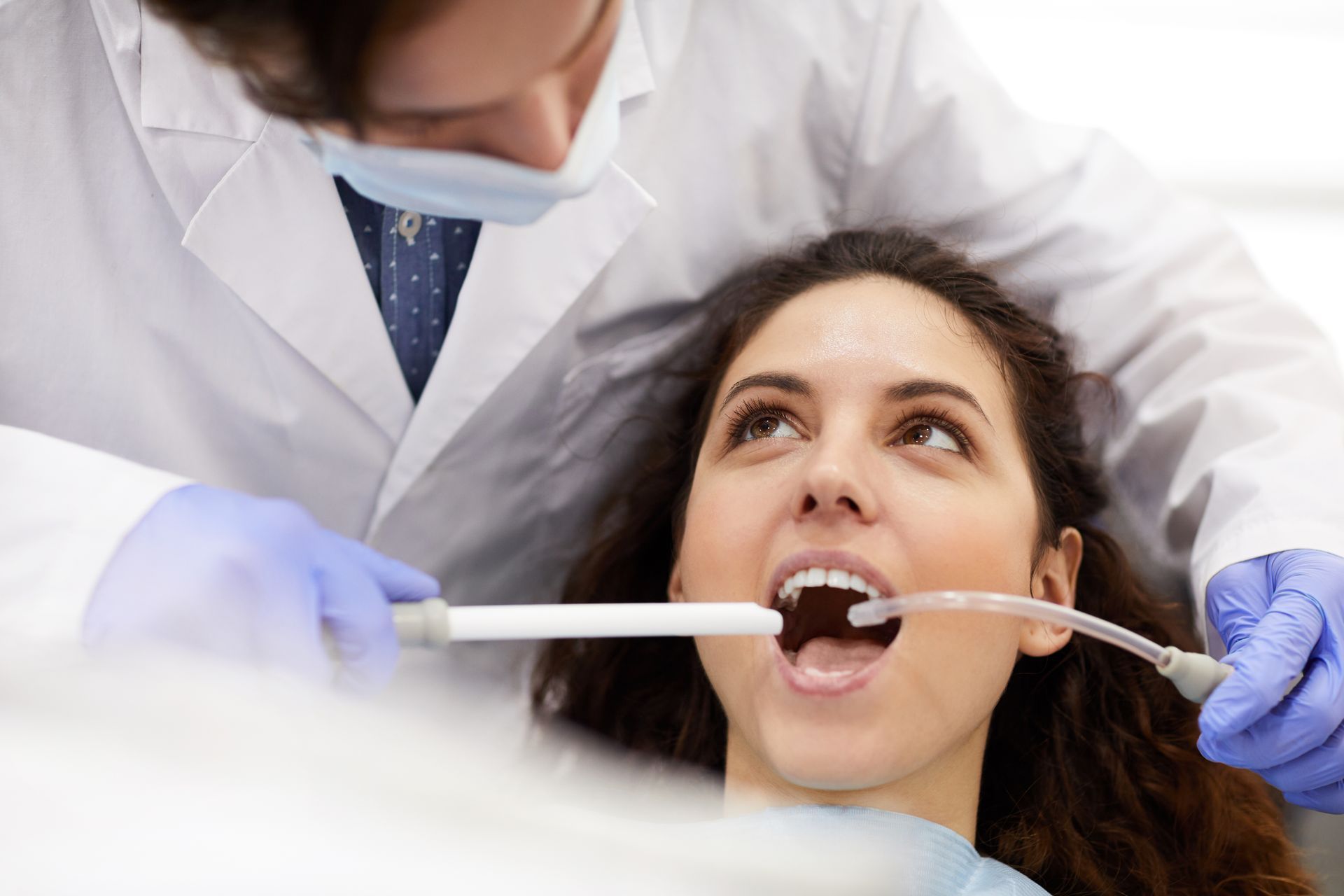 A woman is having her teeth examined by a dentist.