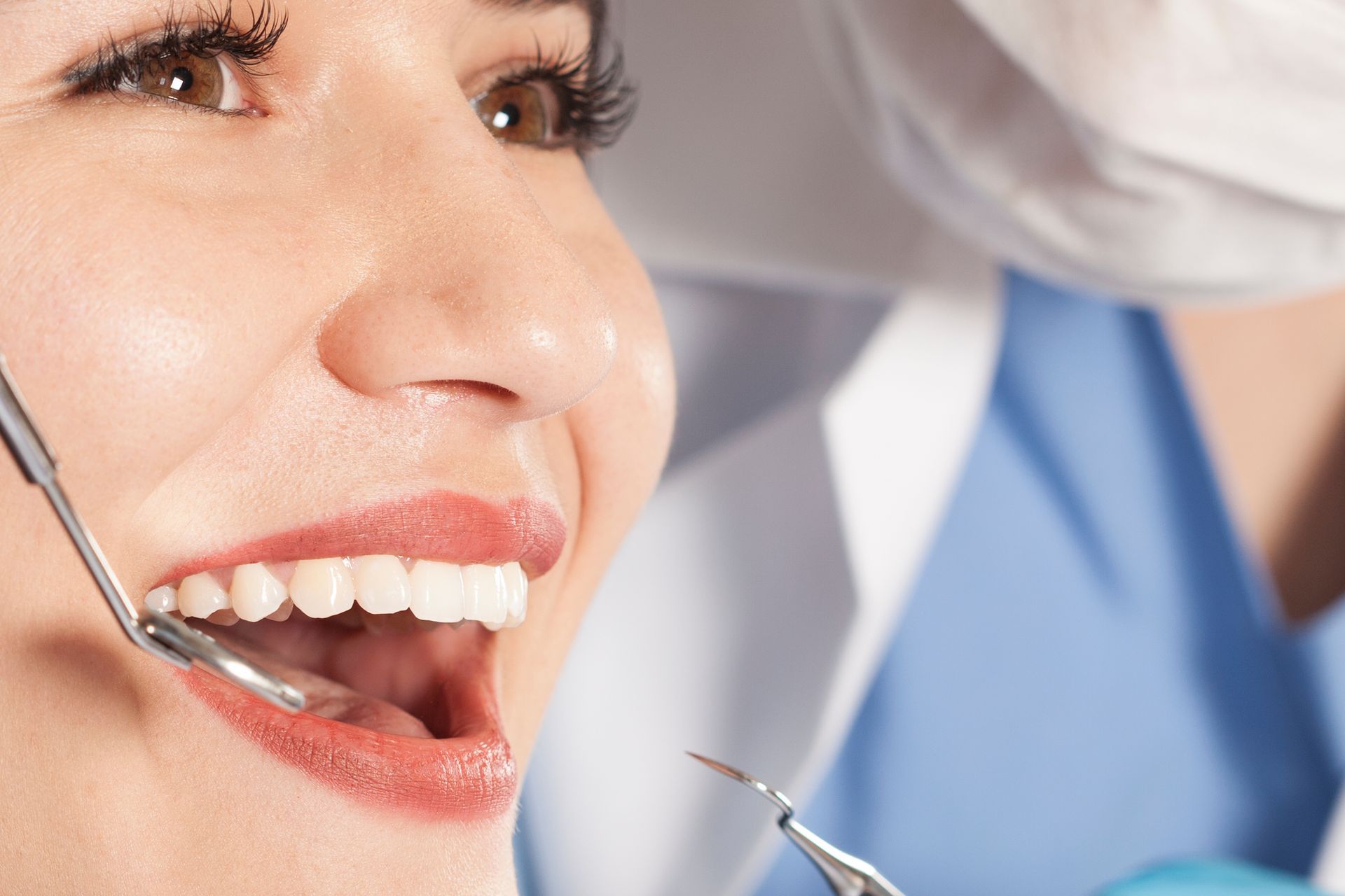 A woman is getting her teeth examined by a dentist.