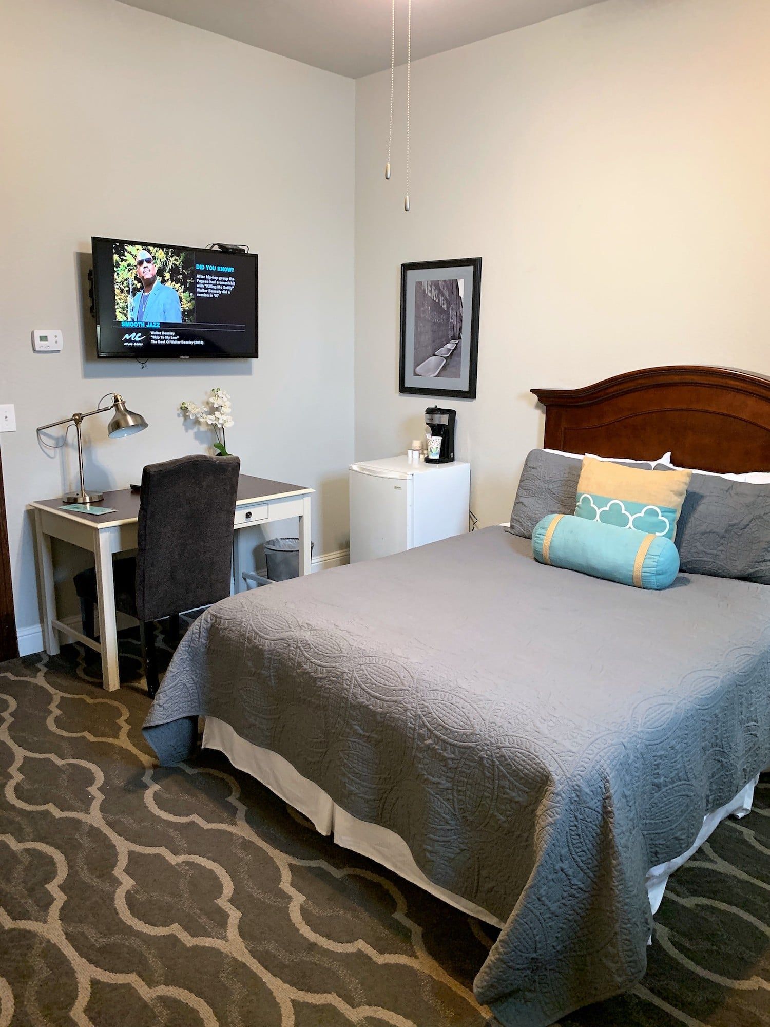 A bedroom with a bed , desk , chair and television.