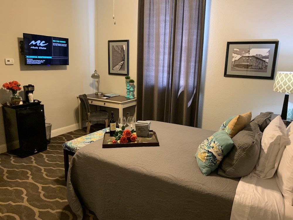 A bedroom with a large bed and a flat screen tv on the wall.