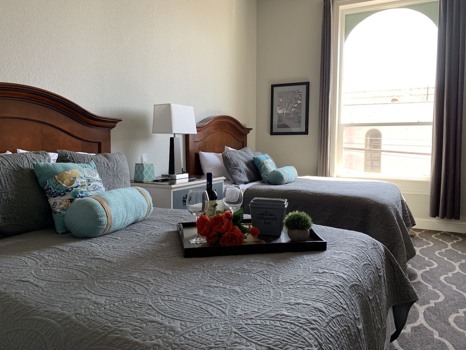A hotel room with two beds and a tray on the bed.