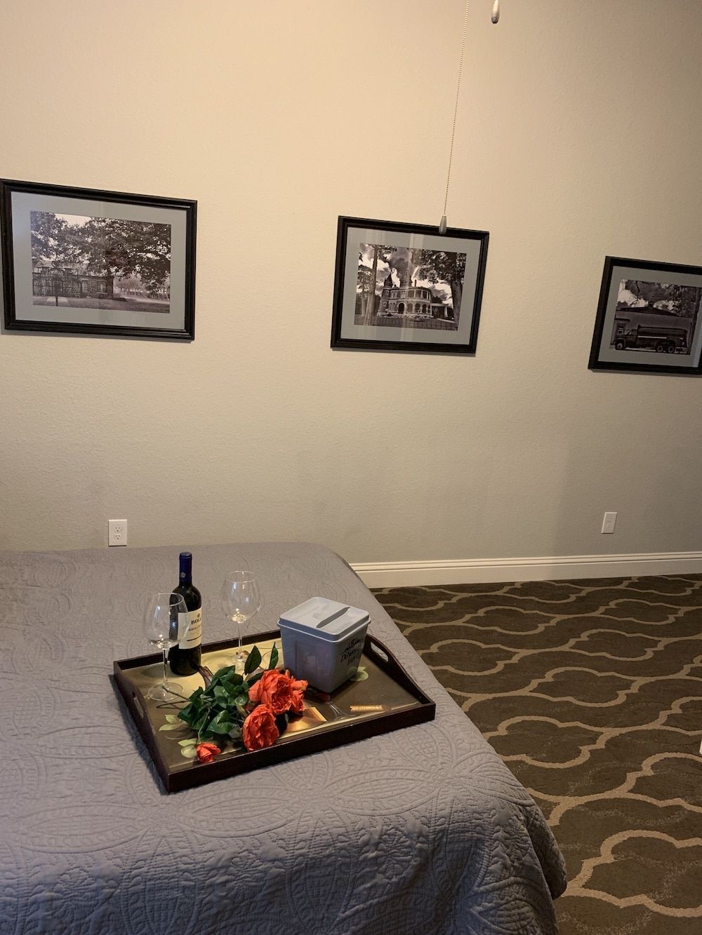 A bed with a tray of food and a bottle of wine on it