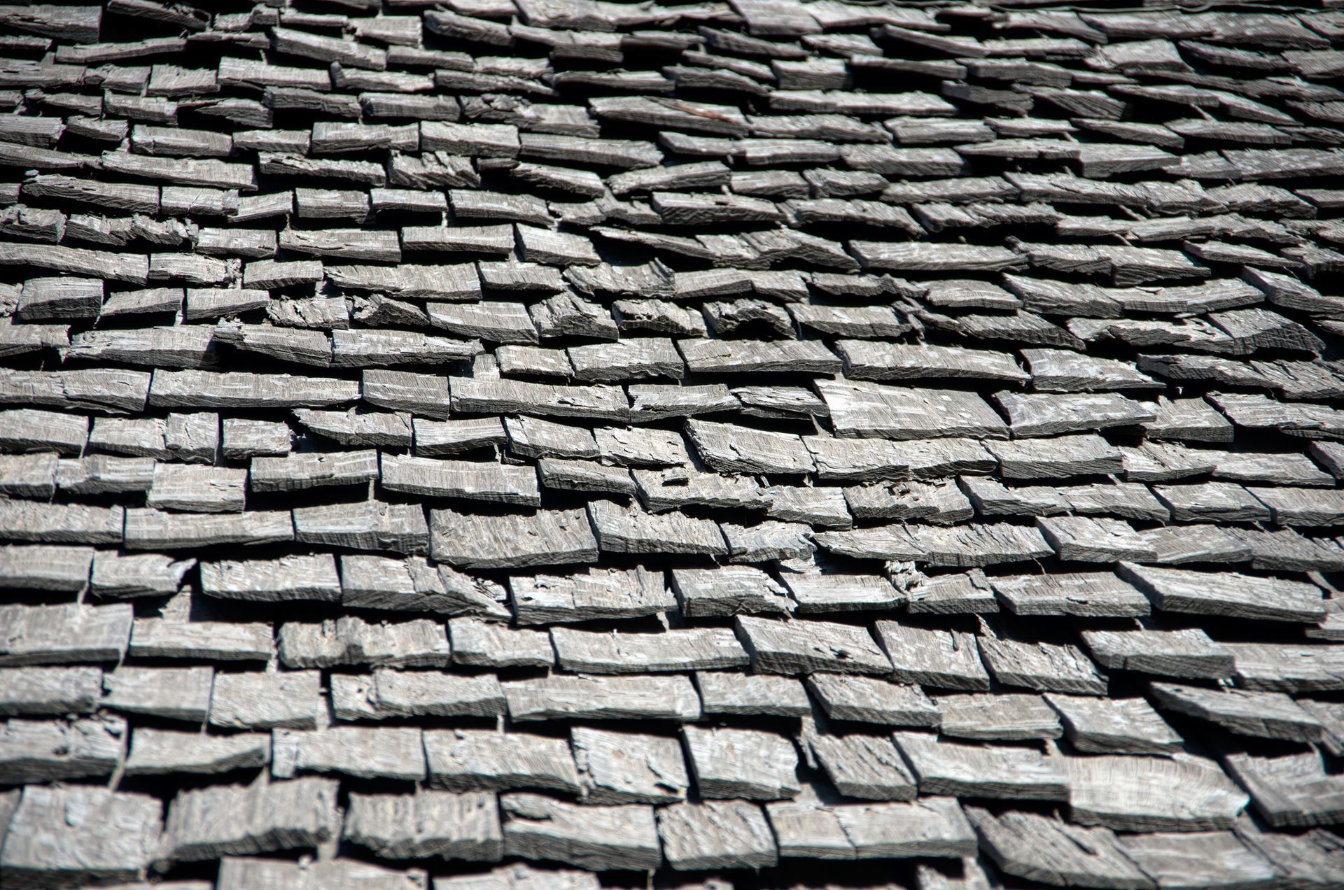 Wooden shingle roof, weathered and gray, close-up view.