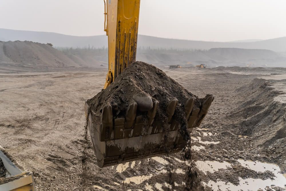 Excavator bucket with ore — Retirement Planning in Queensland