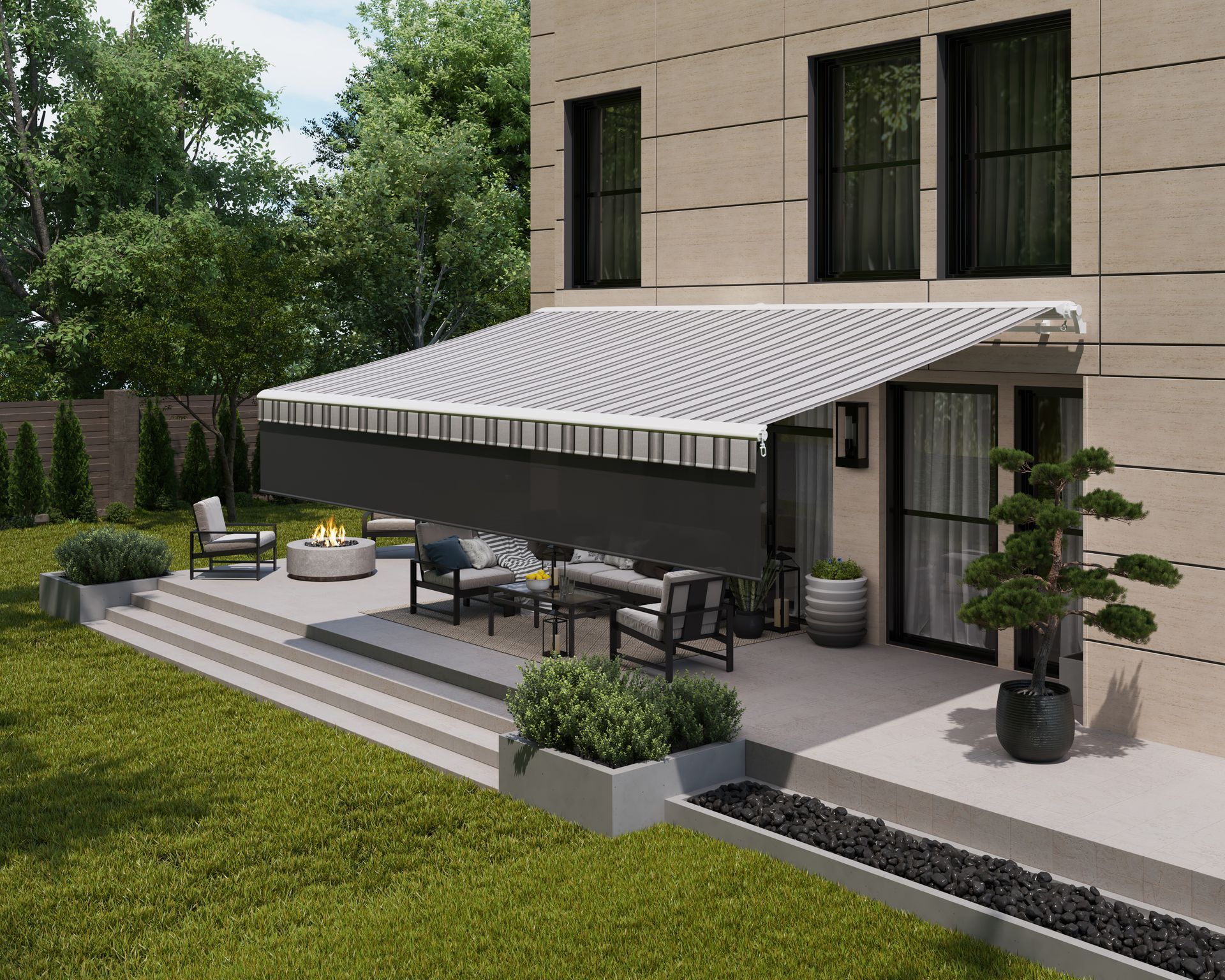 A patio with outdoor seating, a fire pit, and a retractable striped awning attached to a modern stone house.