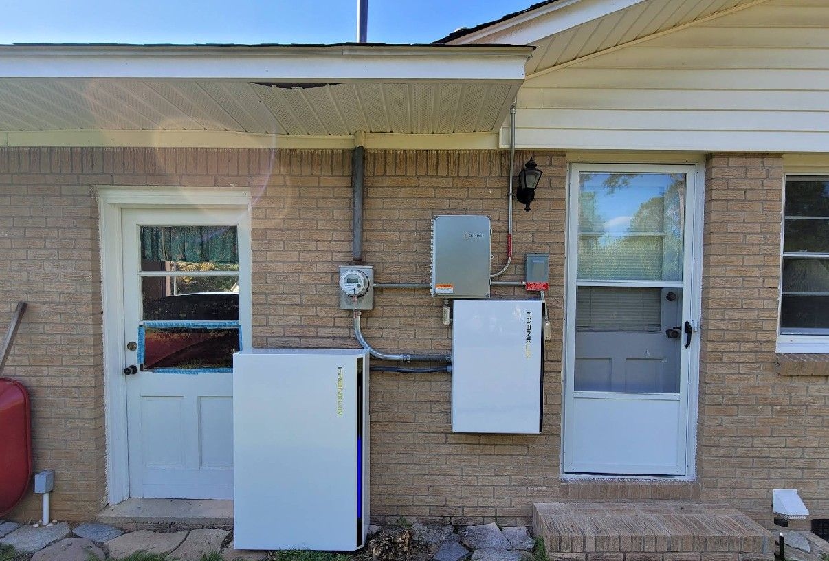 Brick building exterior with two white doors, electrical equipment, and a large white battery box.
