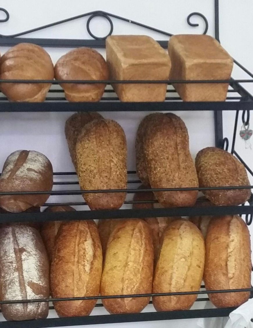 Bread loaves on tiered black metal shelving— Bread Basket in Kurri Kurri, NSW