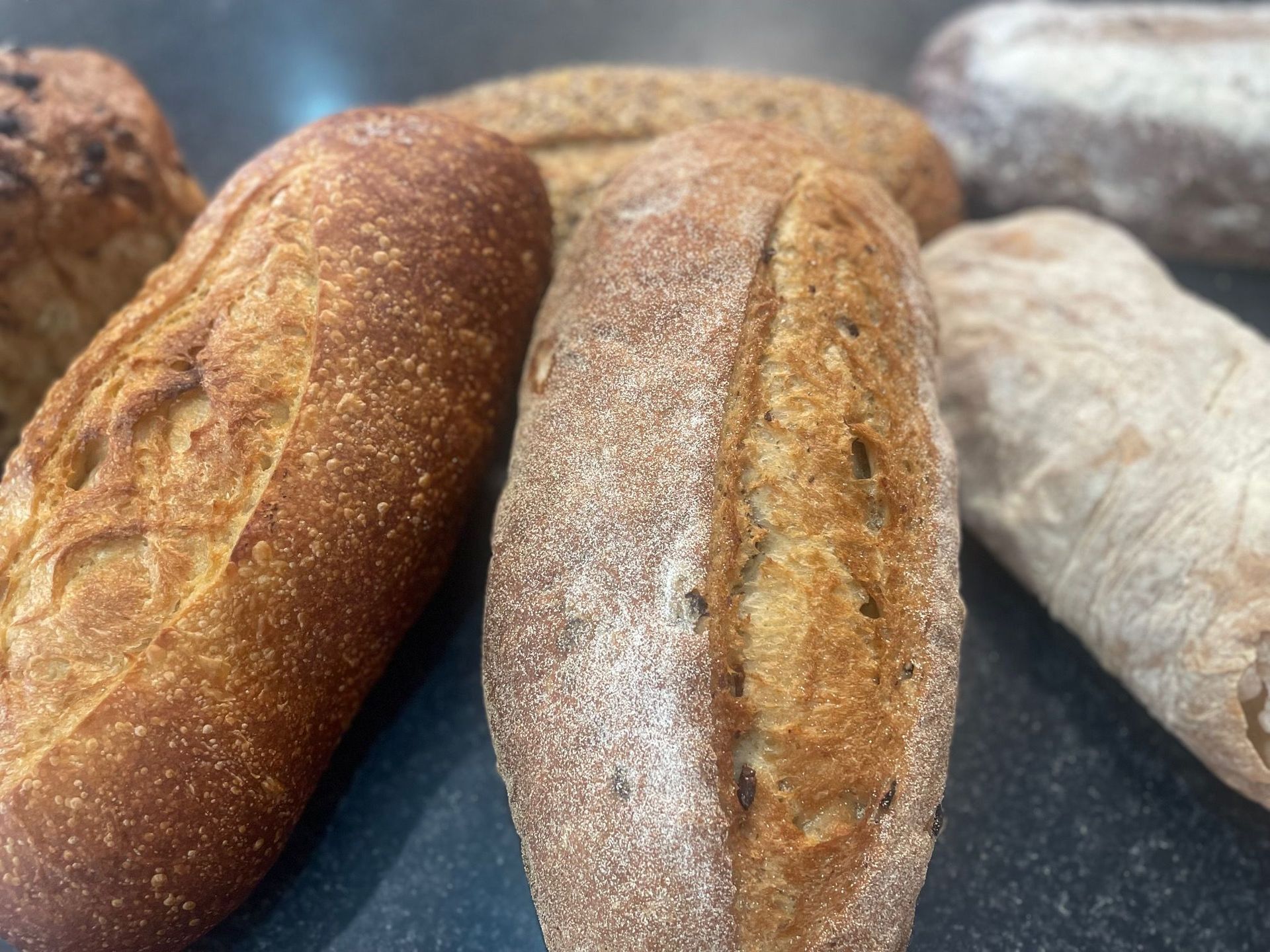 A Bunch of Loafs of Bread piled up in a basket — Bread Basket in Kurri Kurri, NSW