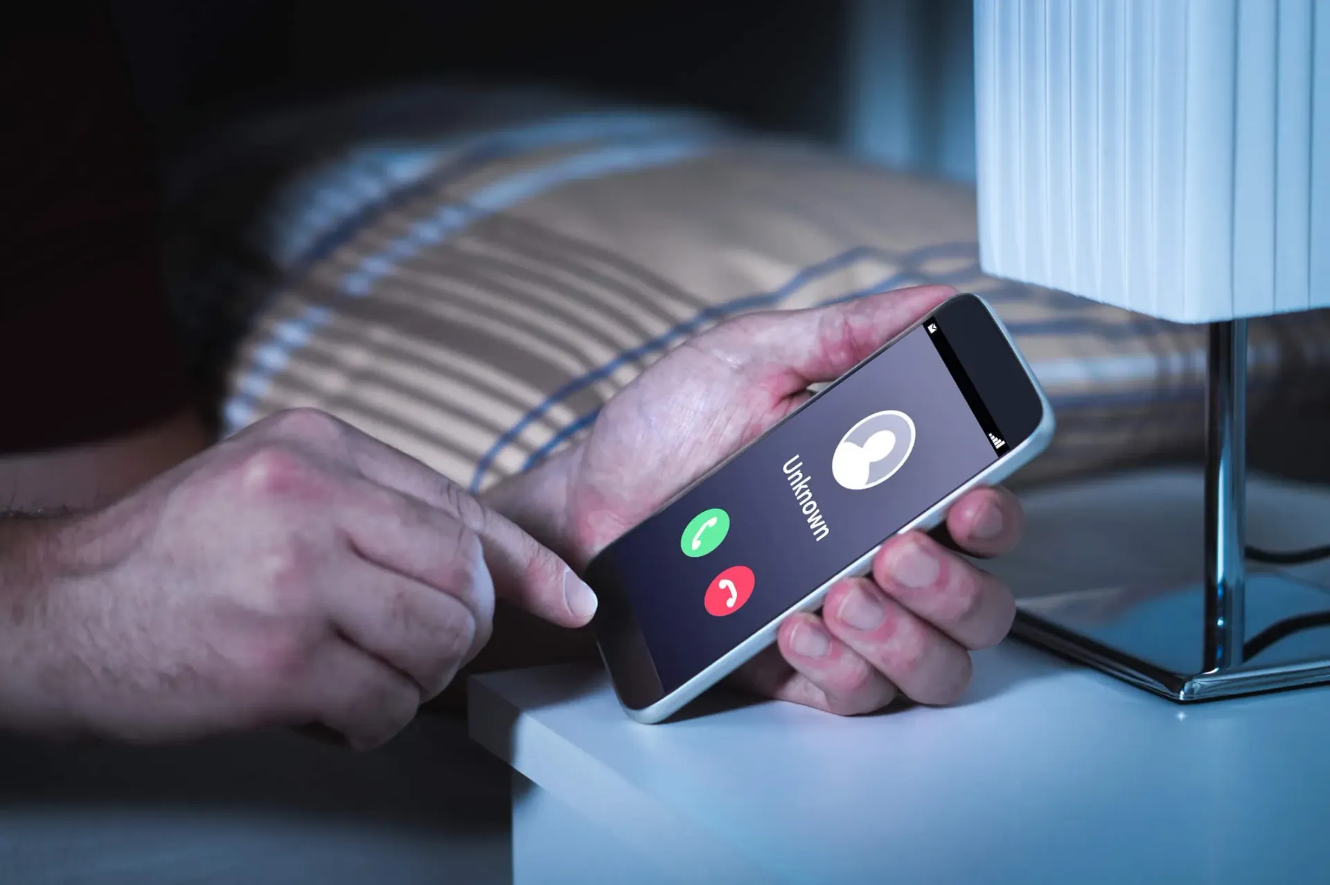 A person receives a fraudulent call from an unknown number on their smartphone 