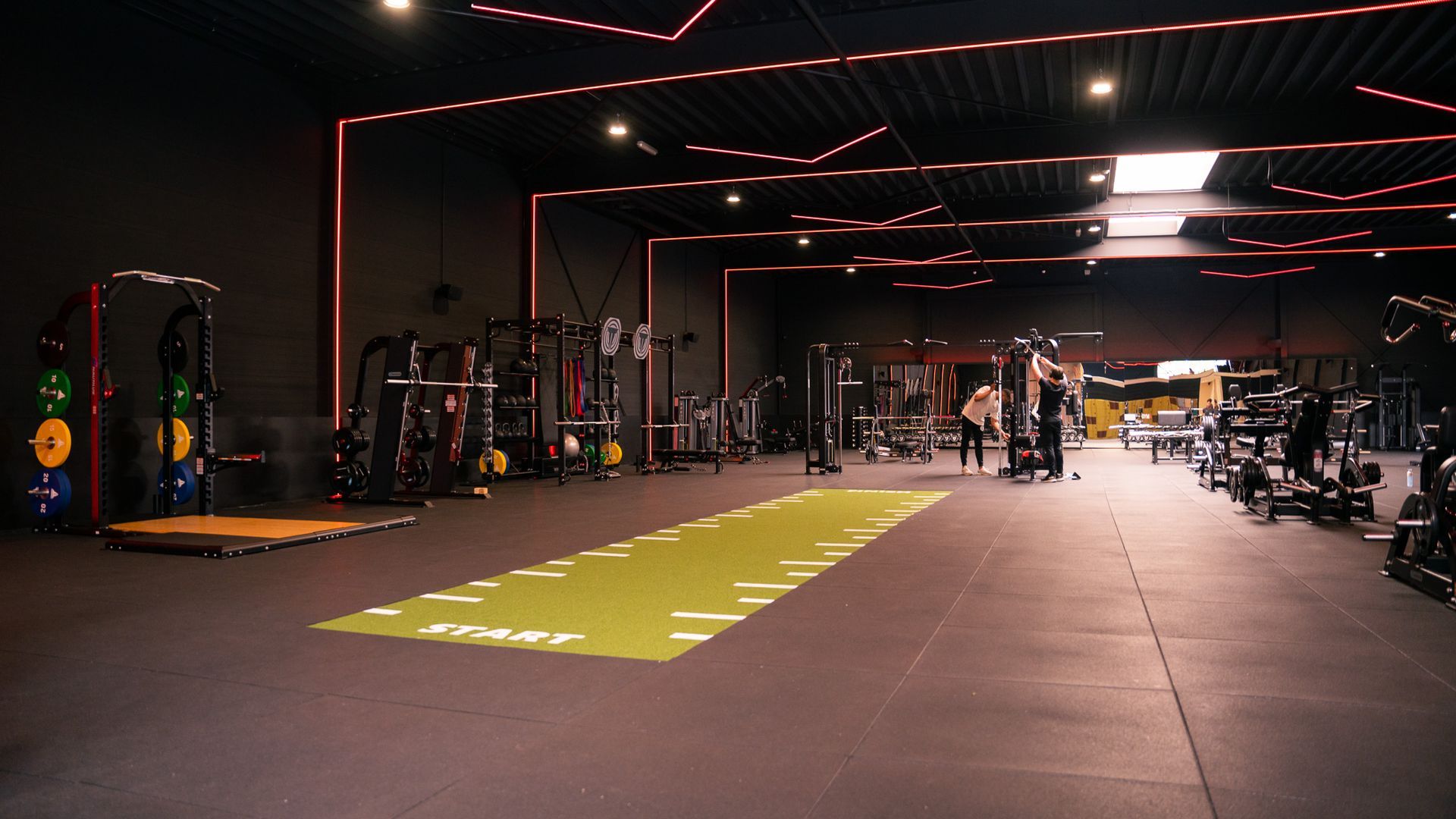 Een grote sportschool vol met fitnessapparatuur.