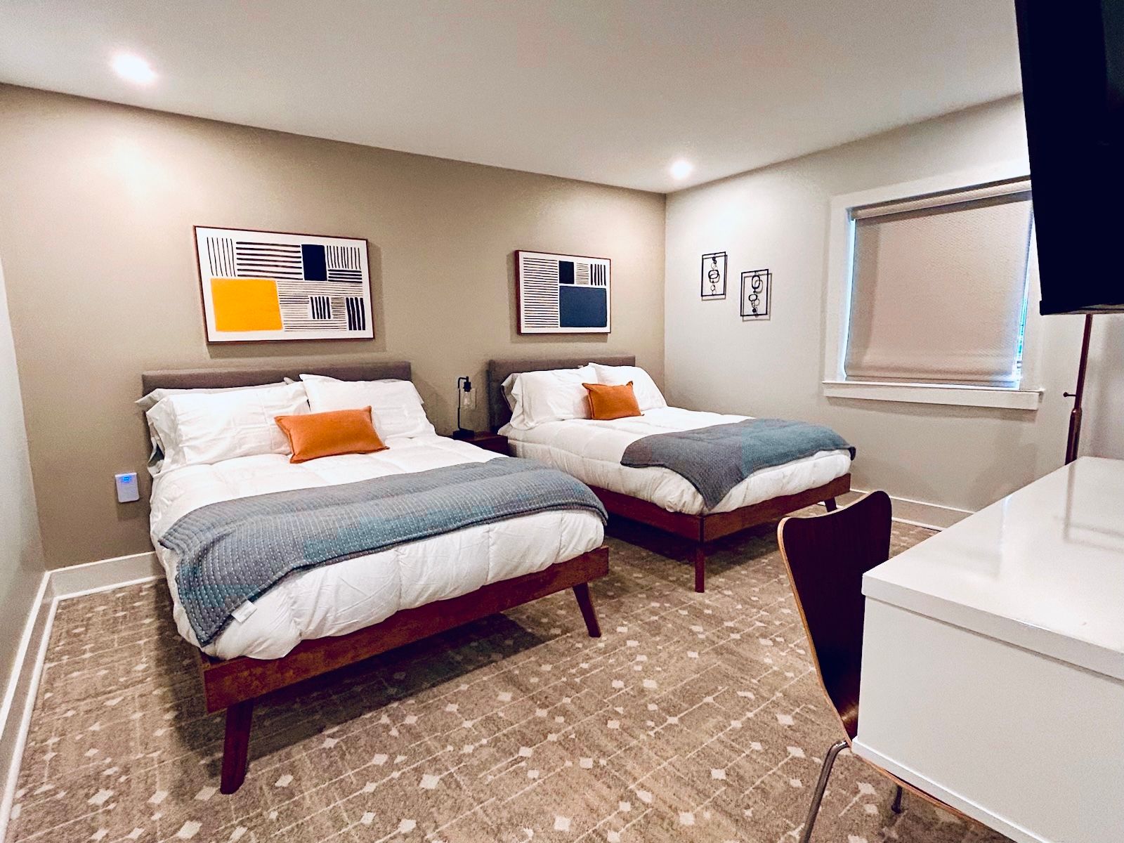 a hotel room with two beds , a desk and a television .