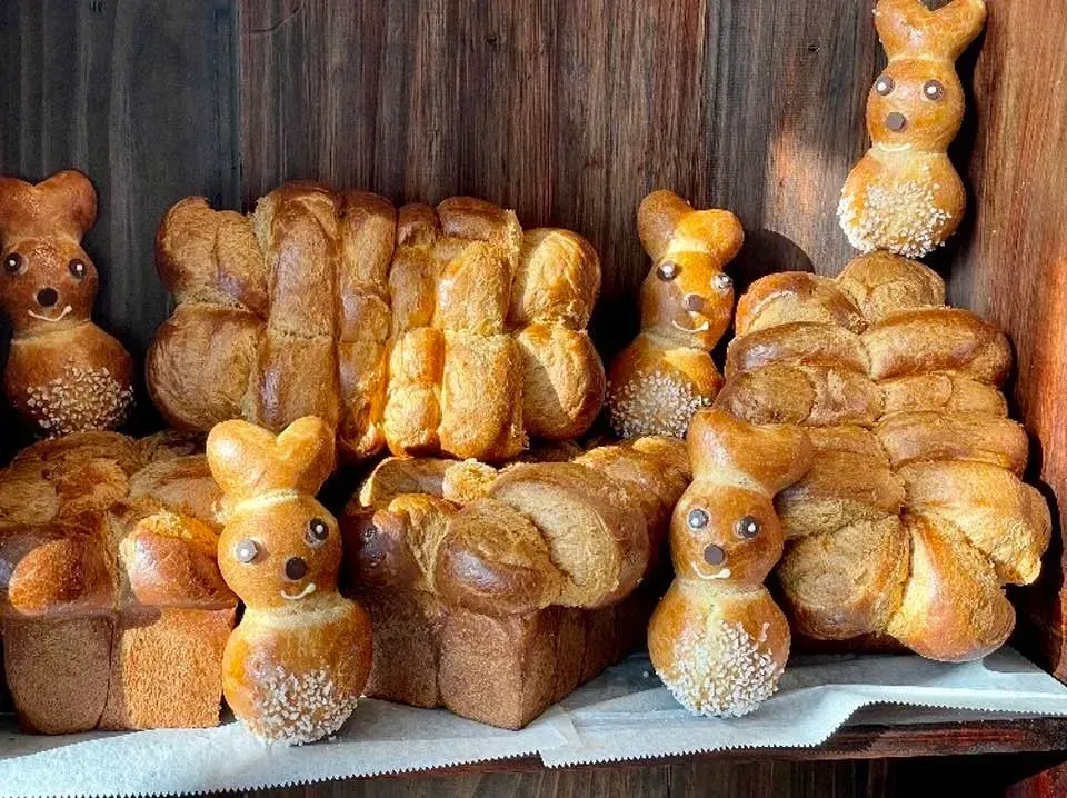 a bunch of bread in the shape of animals are sitting on a shelf .