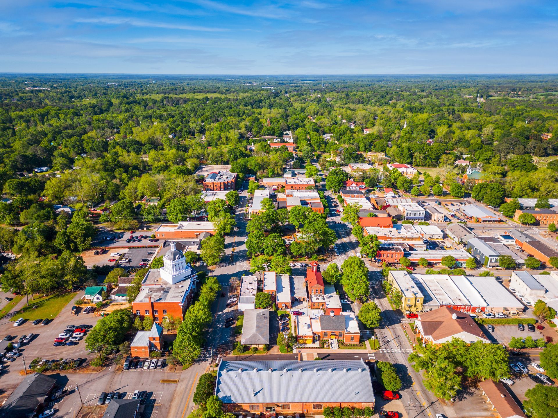 an aerial view of a small town surrounded by trees and buildings .