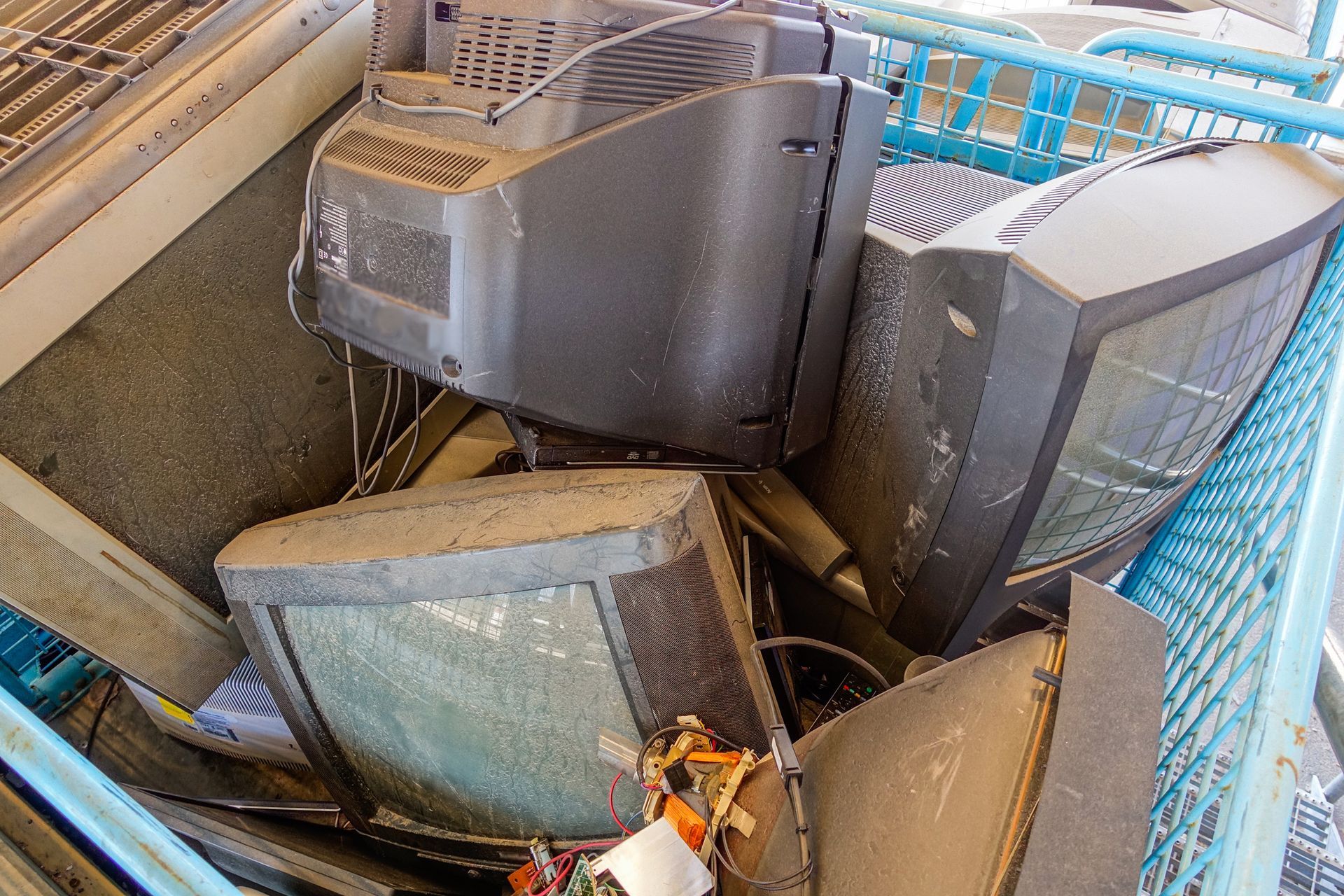 Broken TVs at an appliances recycling center’s dumpster.
