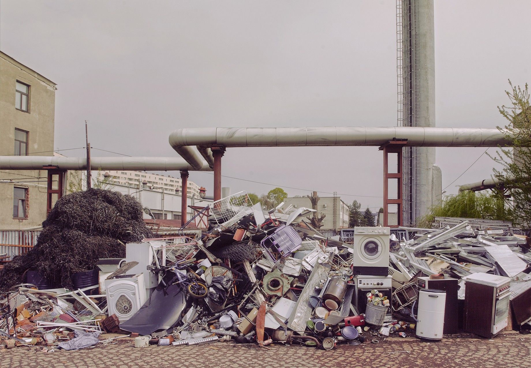 Washing machines, refrigerators, ovens and general junk lying on pile at a recycling center.